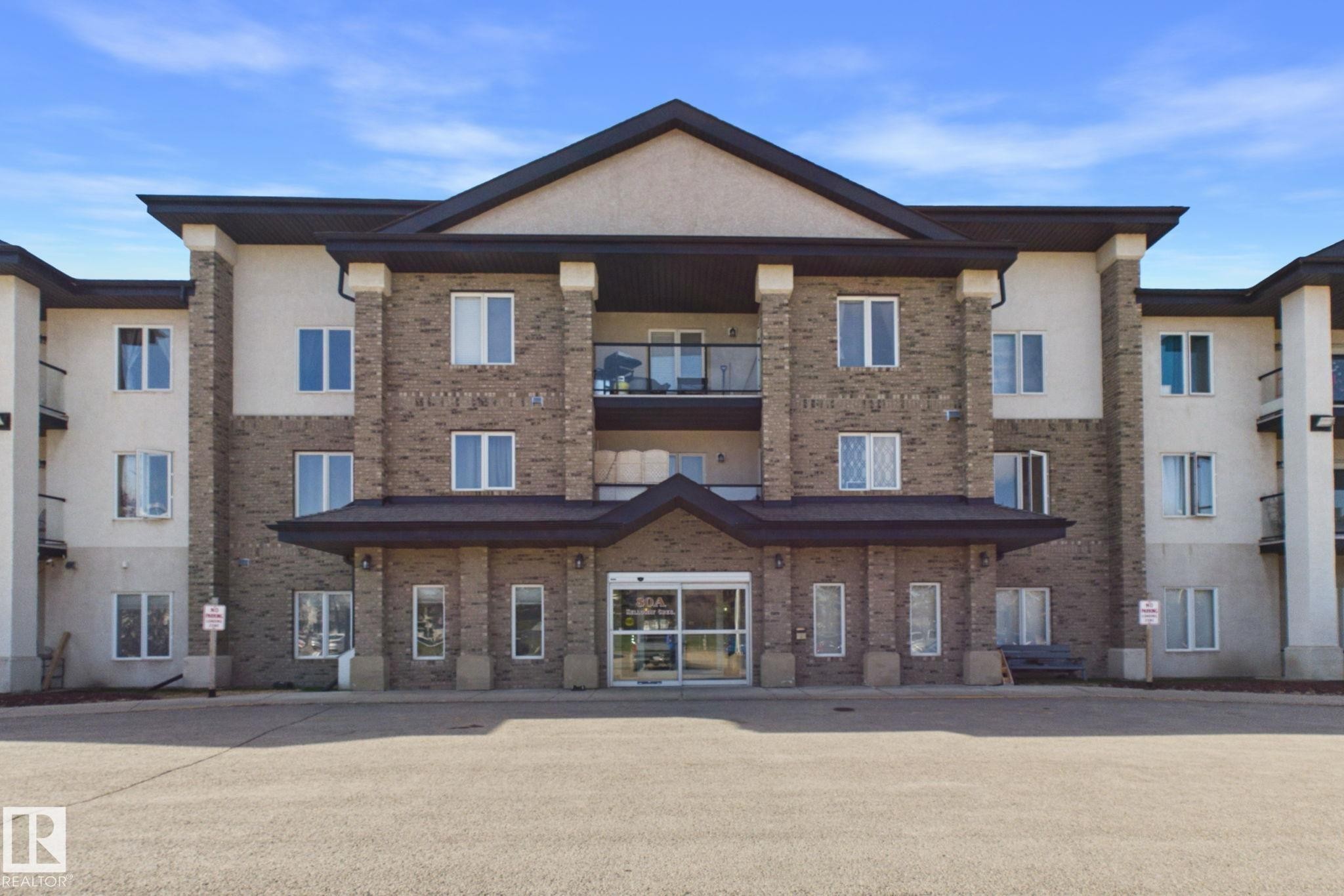 Multi-story residential building featuring brick and stucco exterior - 220 80A Kelloway Crescent, Red Deer, AB - Outdoor With Balcony With Facade