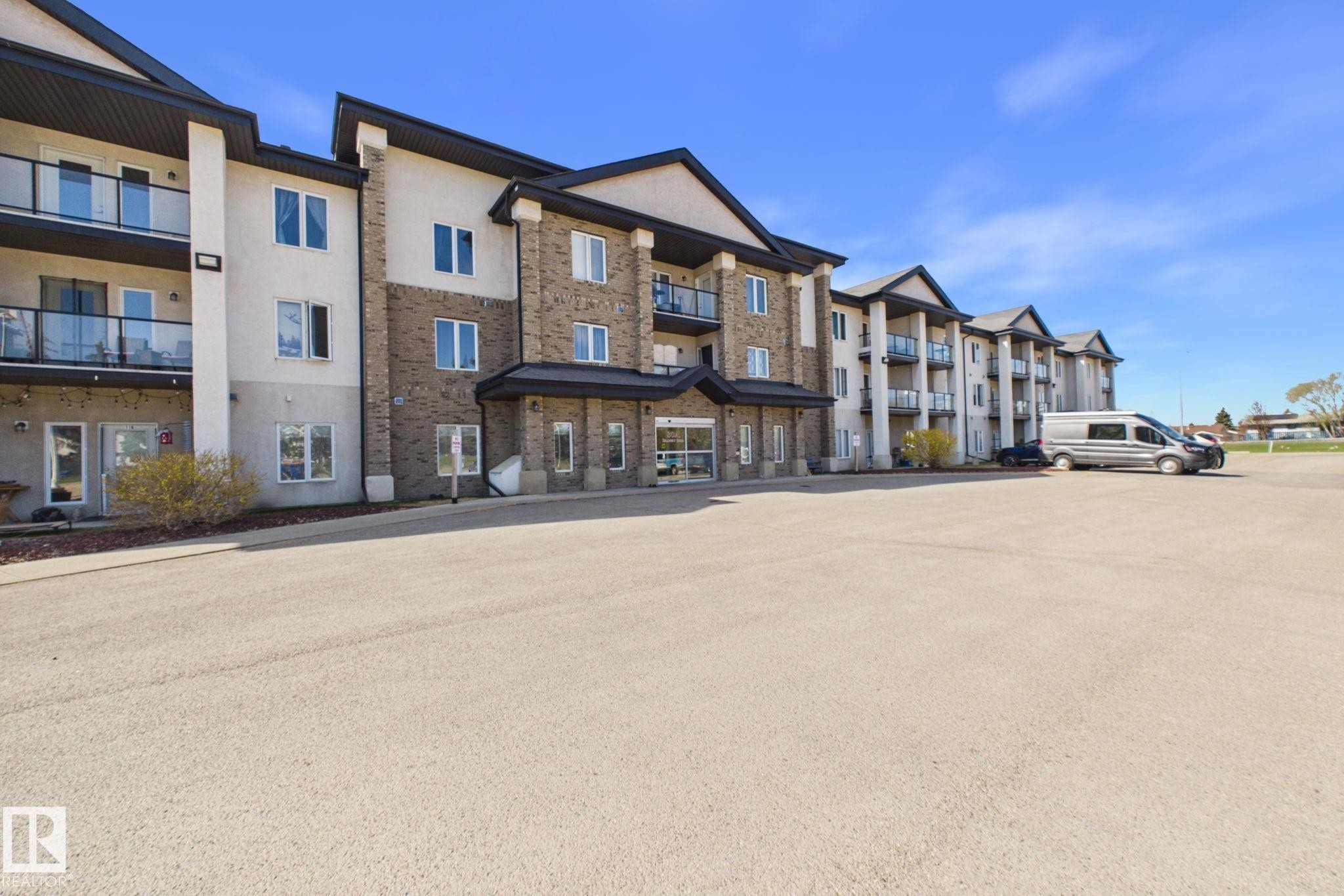 Modern multi-story building featuring brick and stucco facade - 220 80A Kelloway Crescent, Red Deer, AB - Outdoor With Balcony With Facade