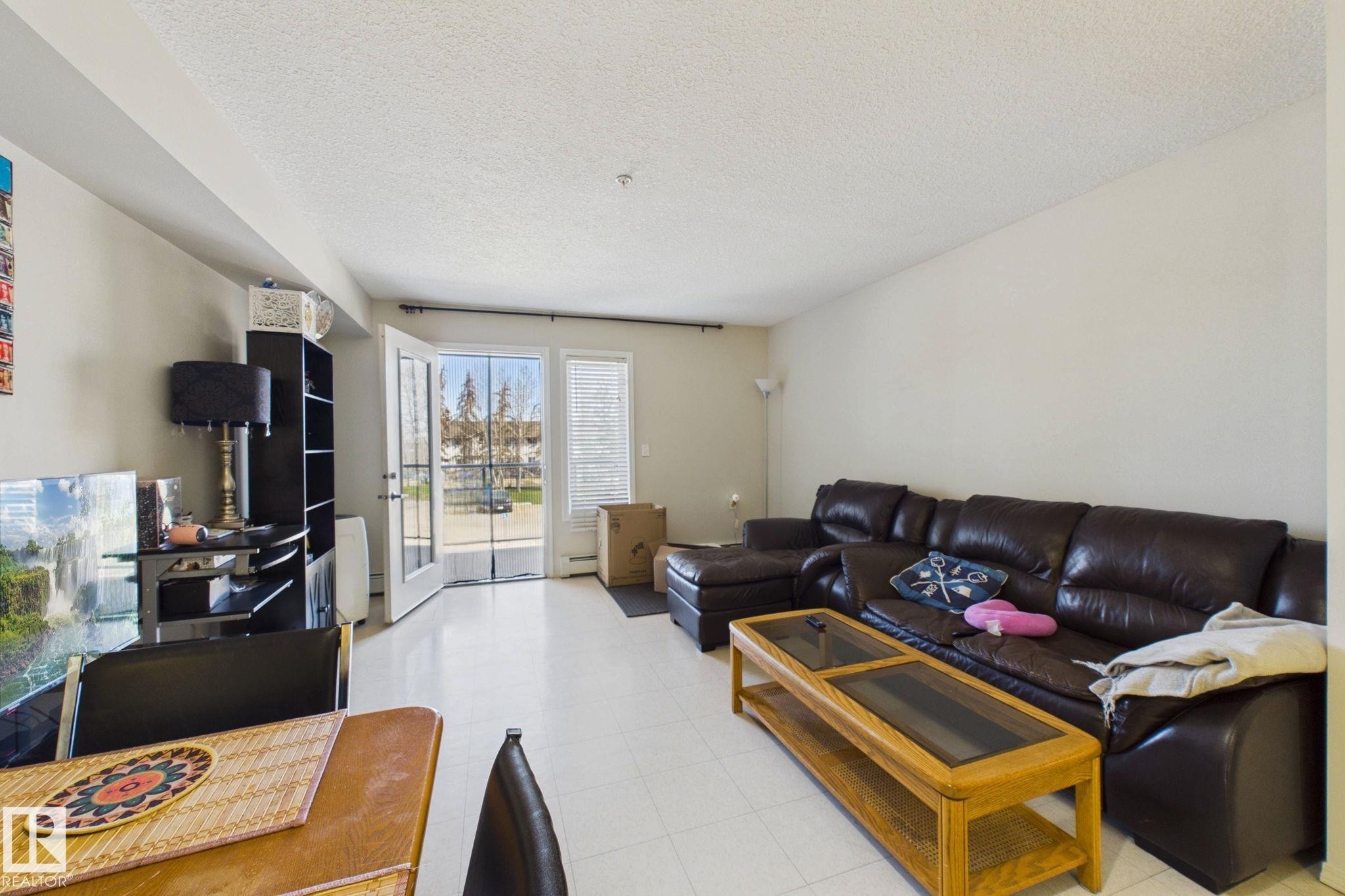 Living area featuring light-colored flooring and neutral-toned walls - 220 80A Kelloway Crescent, Red Deer, AB - Indoor Photo Showing Living Room