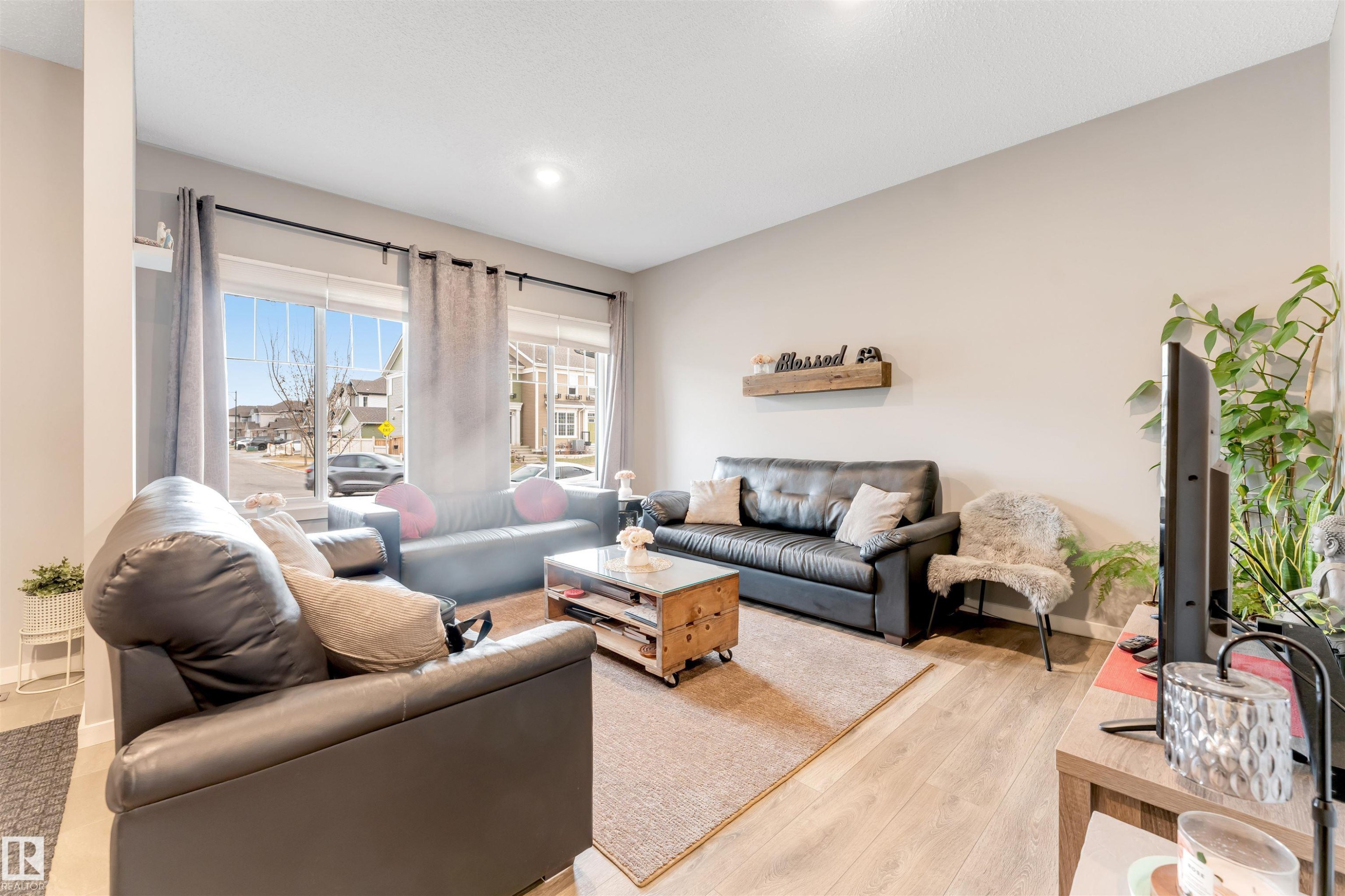 Spacious living area featuring light wood-finish flooring and neutral wall tones - 2652 Maple Way, Edmonton, AB - Indoor Photo Showing Living Room