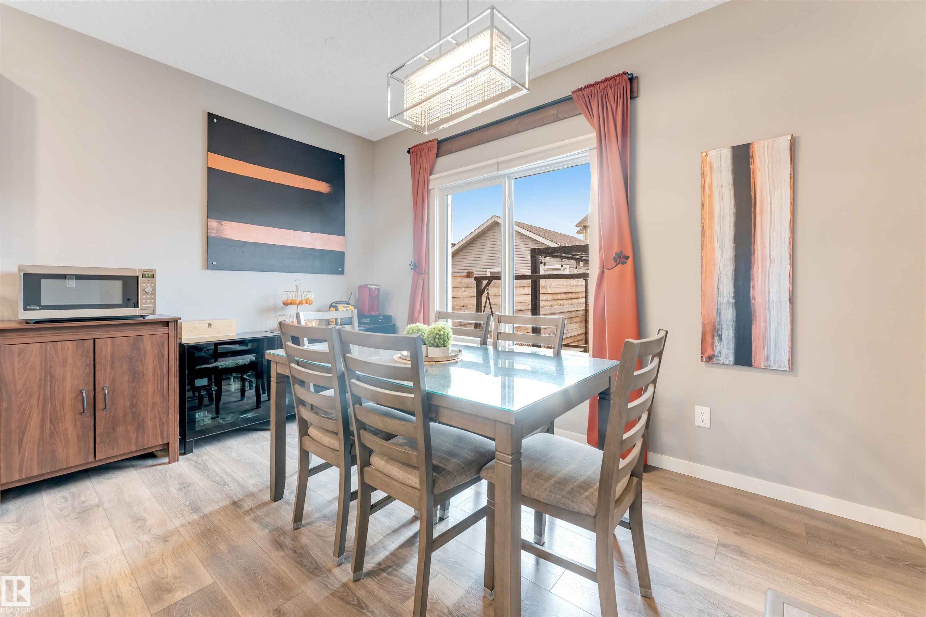 Dining space featuring wood-finish flooring, a sliding glass door, and a rectangular ceiling light fixture - 2652 Maple Way, Edmonton, AB - Indoor Photo Showing Dining Room