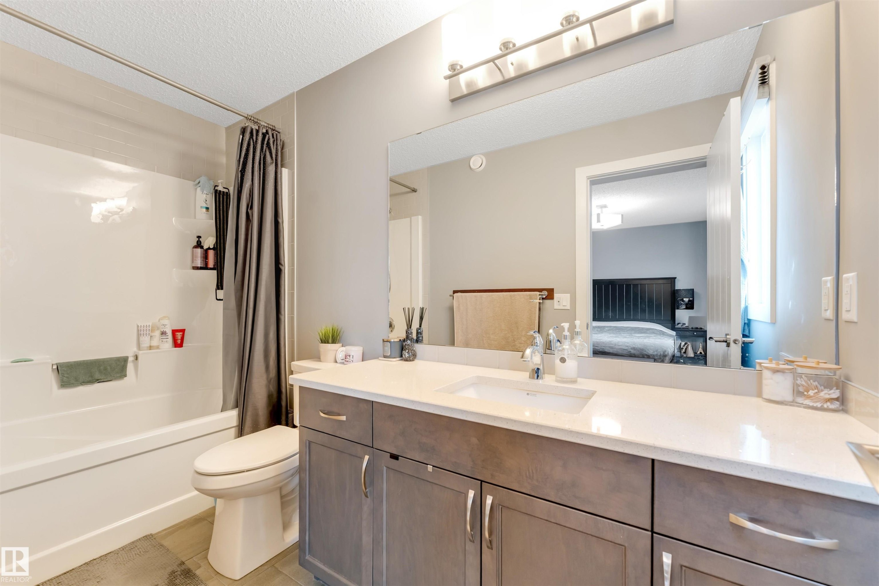 Bathroom featuring a large vanity with a light countertop, a single undermount sink, and a chrome faucet - 2652 Maple Way, Edmonton, AB - Indoor Photo Showing Bathroom