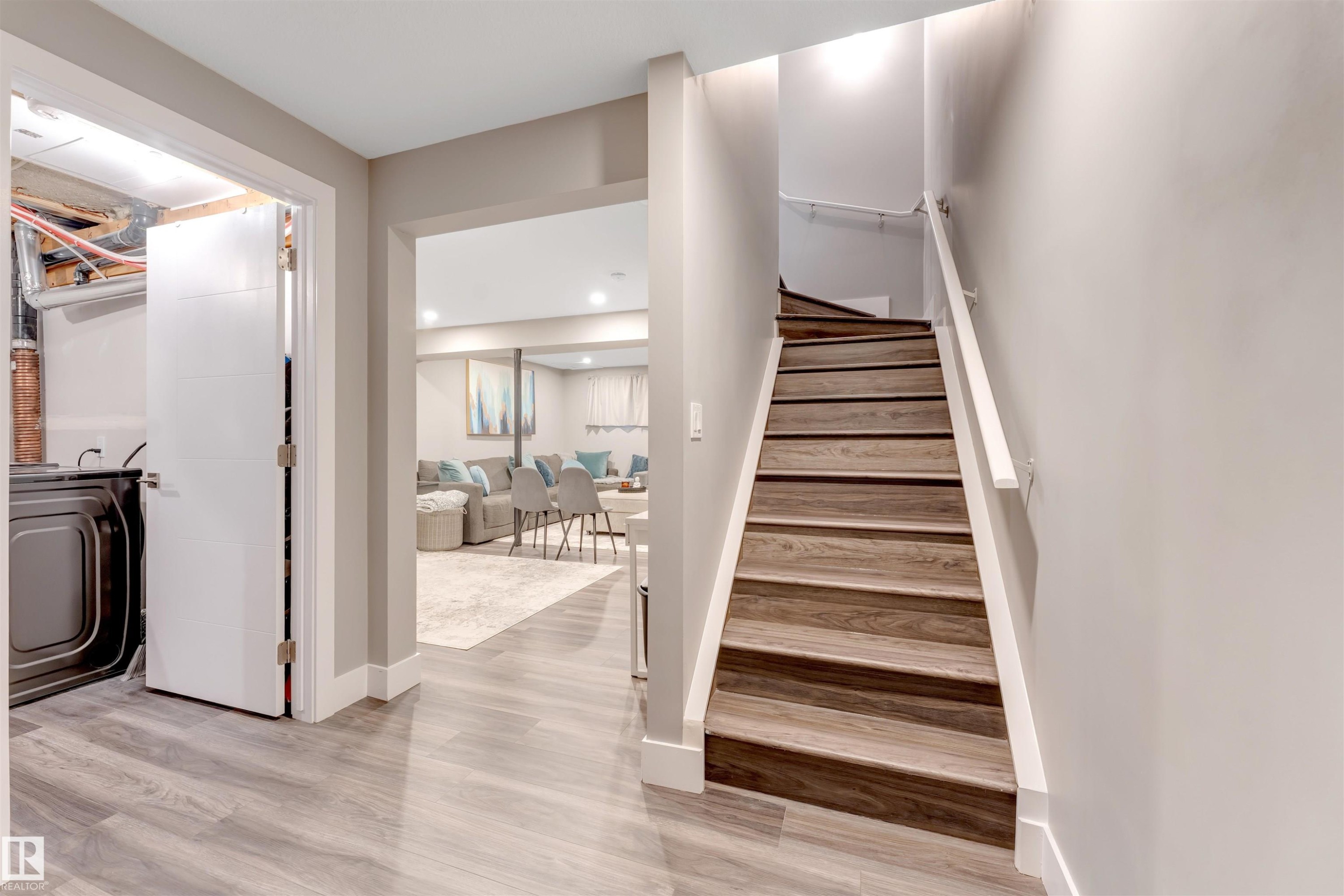 Staircase featuring wood-finish treads and white risers with a coordinating white handrail - 2652 Maple Way, Edmonton, AB - Indoor
