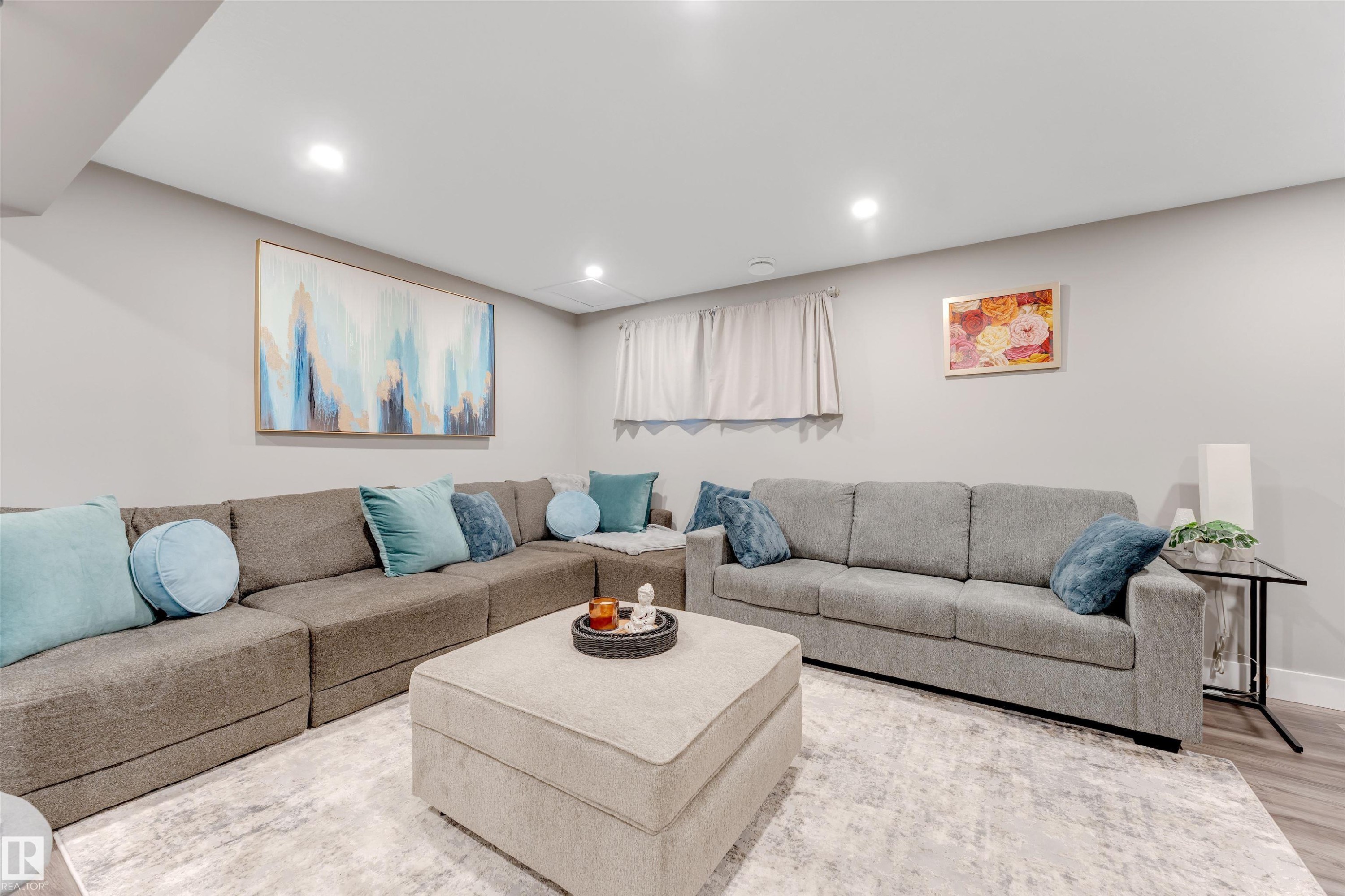 Spacious living area featuring light gray walls, recessed lighting, and wood-finish flooring - 2652 Maple Way, Edmonton, AB - Indoor