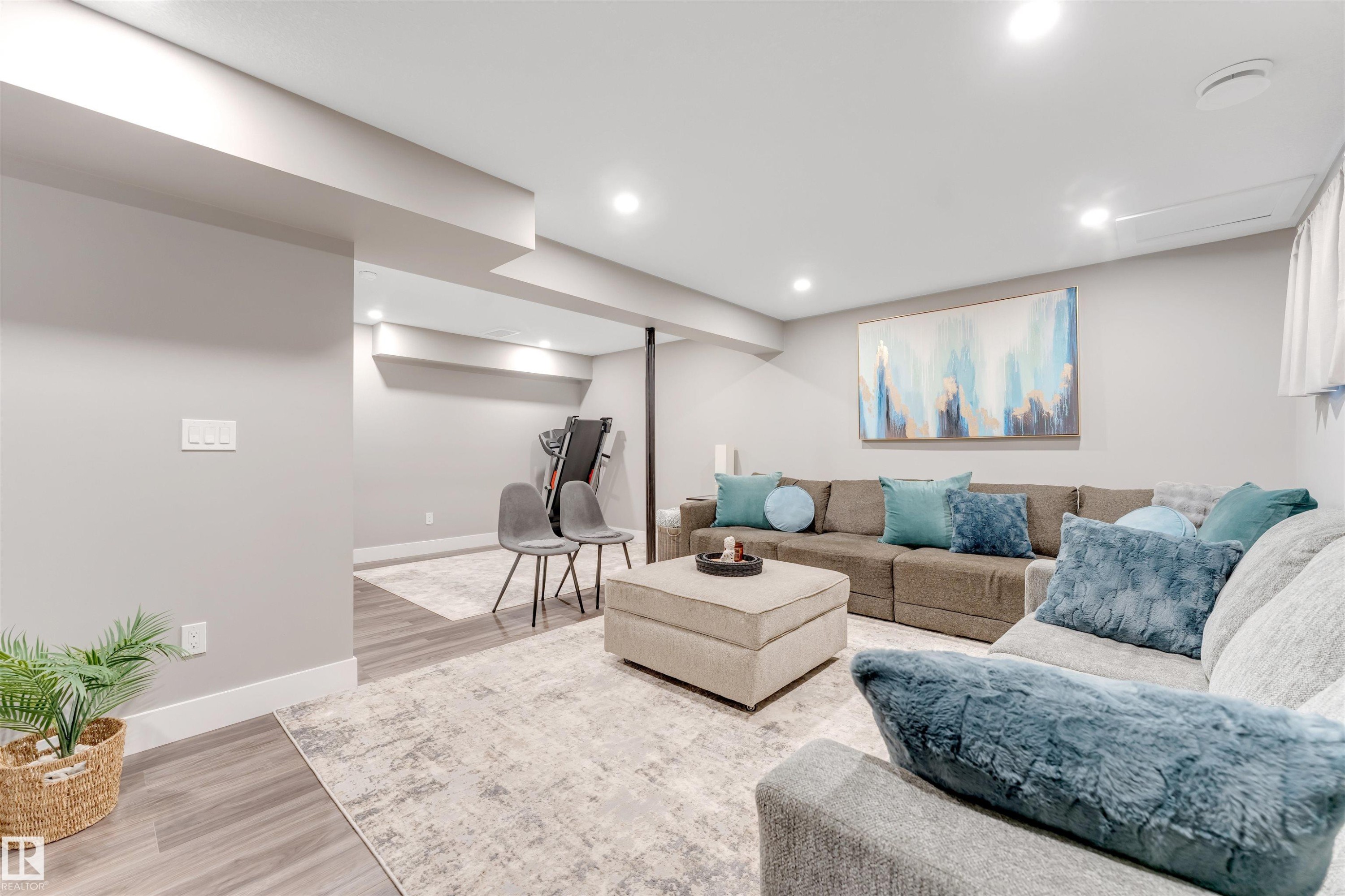 Spacious recreation room featuring recessed lighting, light gray walls, wood-finish flooring, and a large area rug - 2652 Maple Way, Edmonton, AB - Indoor