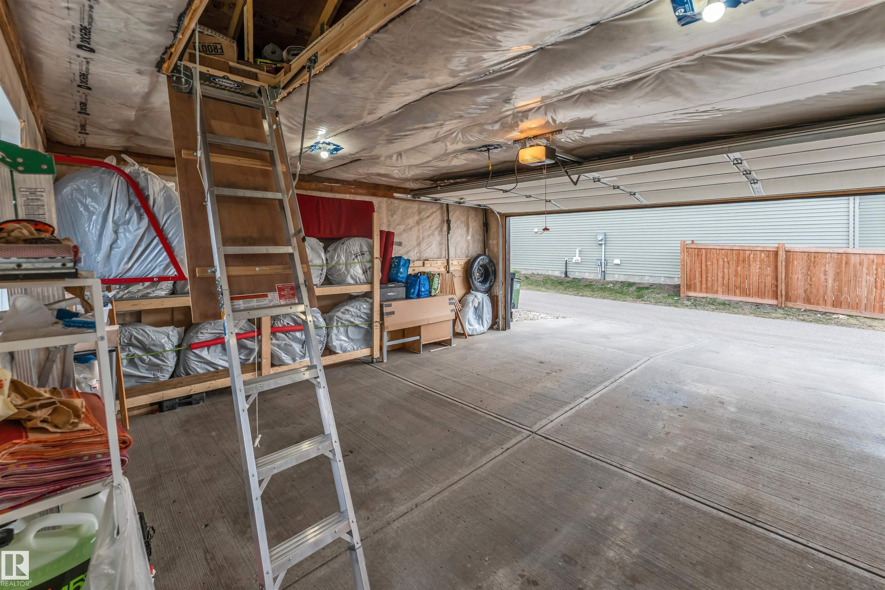 Attached garage with exposed wood beam ceiling, concrete flooring, and an overhead door - 2652 Maple Way, Edmonton, AB - Indoor Photo Showing Garage