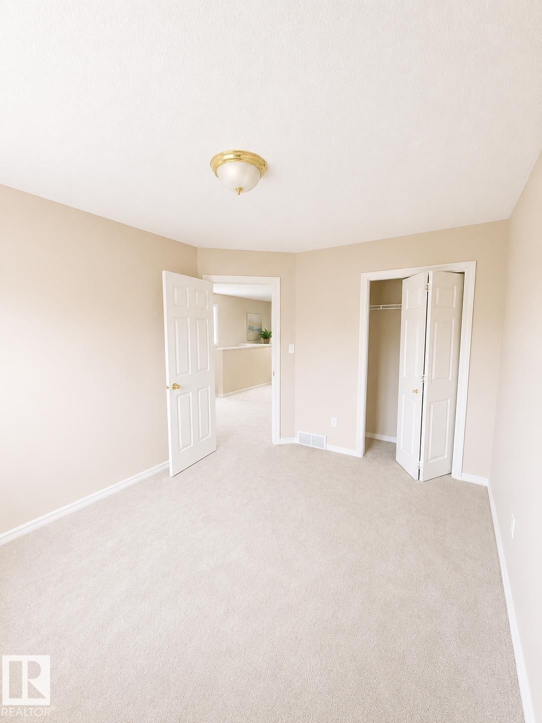 Neutral-toned carpeted interior space featuring a ceiling-mounted light fixture - 704 83 Street, Edmonton, AB - Indoor Photo Showing Other Room