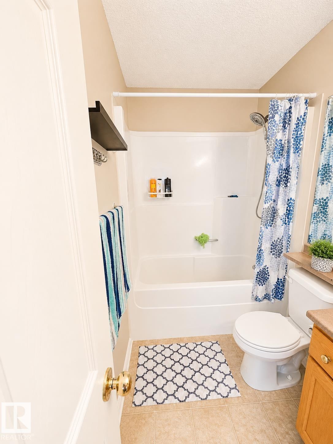 Full bathroom featuring a white tub and shower combination, a toilet, and a vanity with a light wood finish - 704 83 Street, Edmonton, AB - Indoor Photo Showing Bathroom