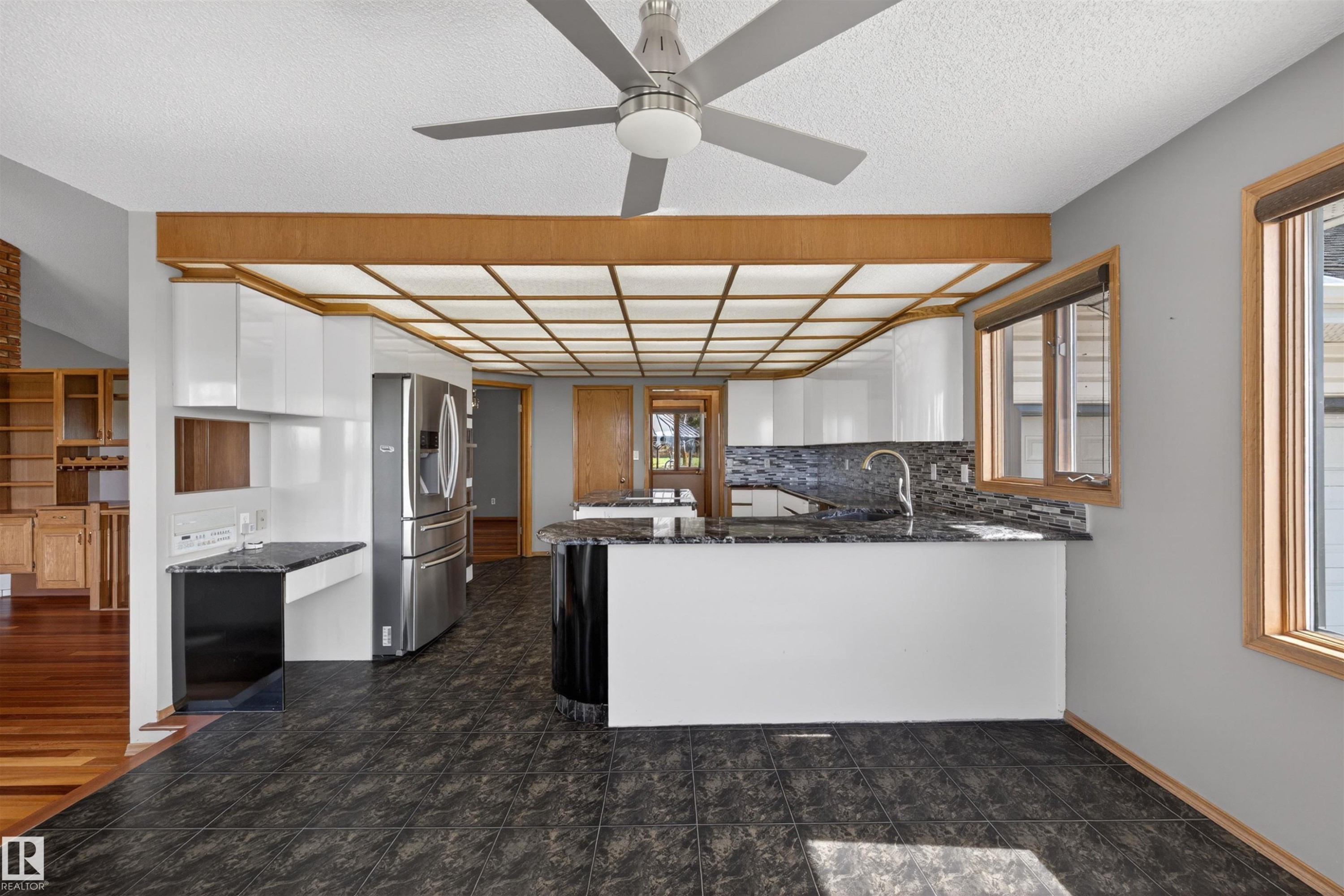 Kitchen featuring dark tile flooring, white cabinetry, dark stone countertops, and a modern ceiling fan - 19403 Fort Road, Edmonton, AB - Indoor Photo Showing Kitchen