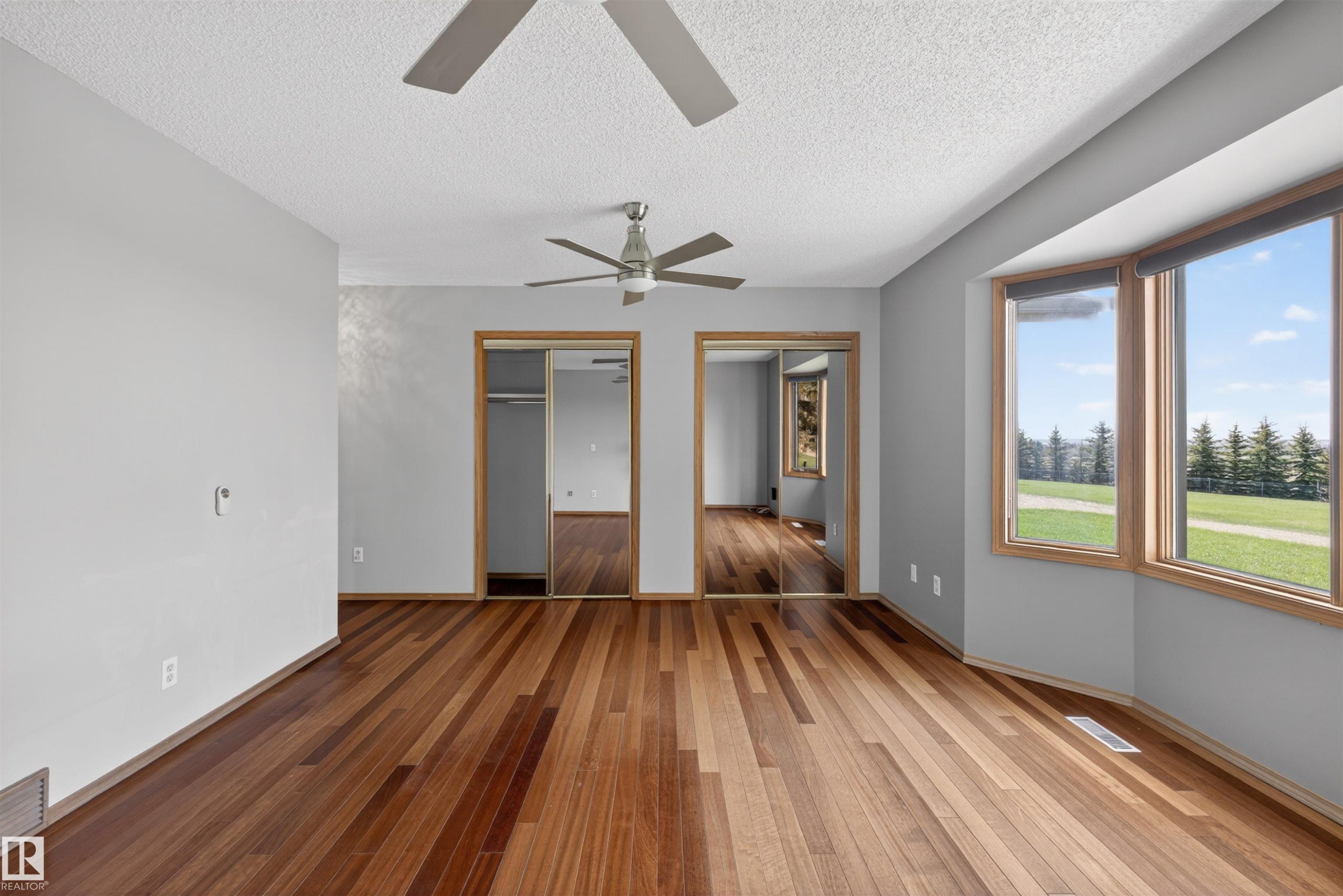 Spacious room featuring wood-finish flooring and light gray walls - 19403 Fort Road, Edmonton, AB - Indoor Photo Showing Other Room