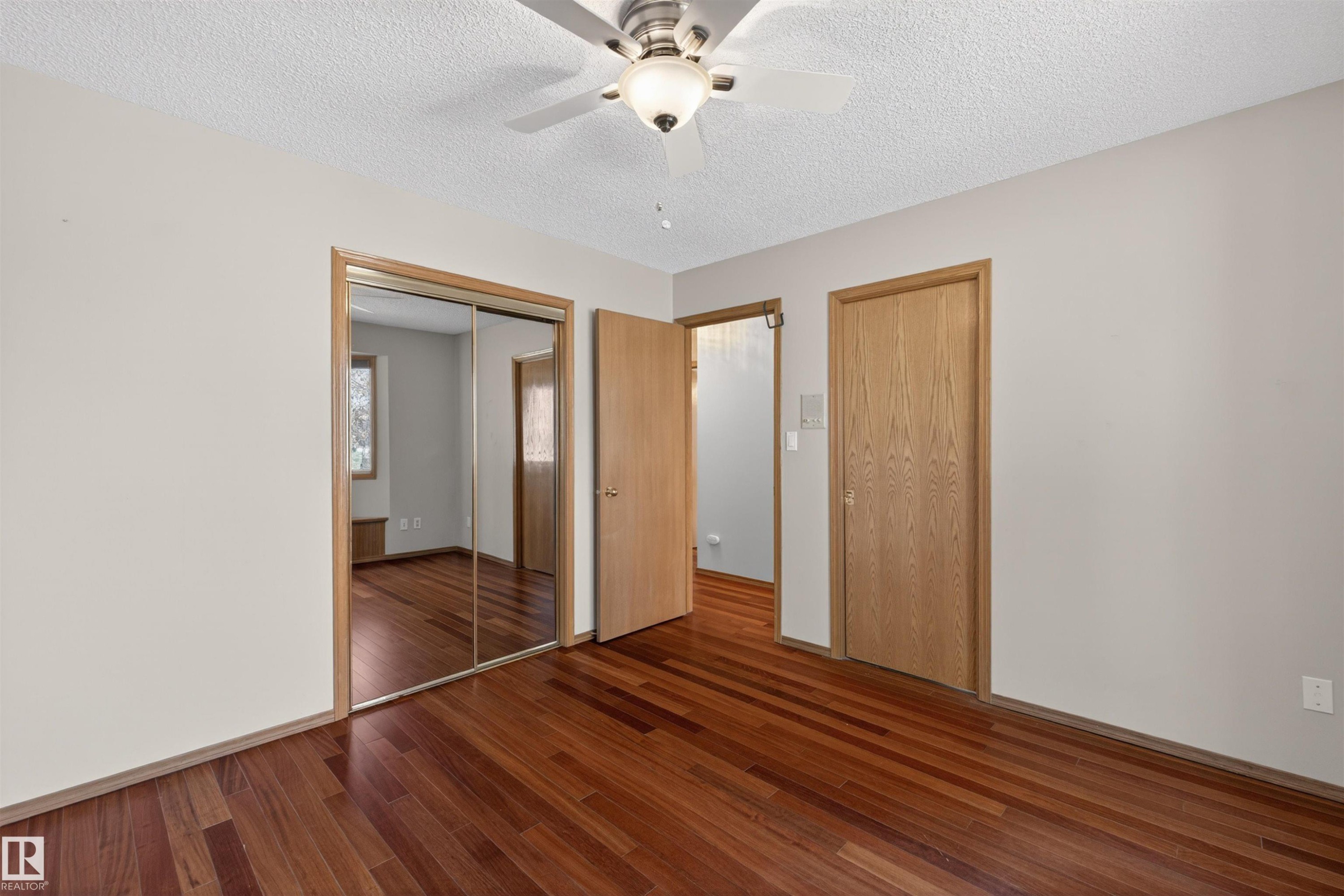 Room featuring wood-finish flooring, a ceiling fan with integrated lighting, and light-toned wall paint - 19403 Fort Road, Edmonton, AB - Indoor Photo Showing Other Room