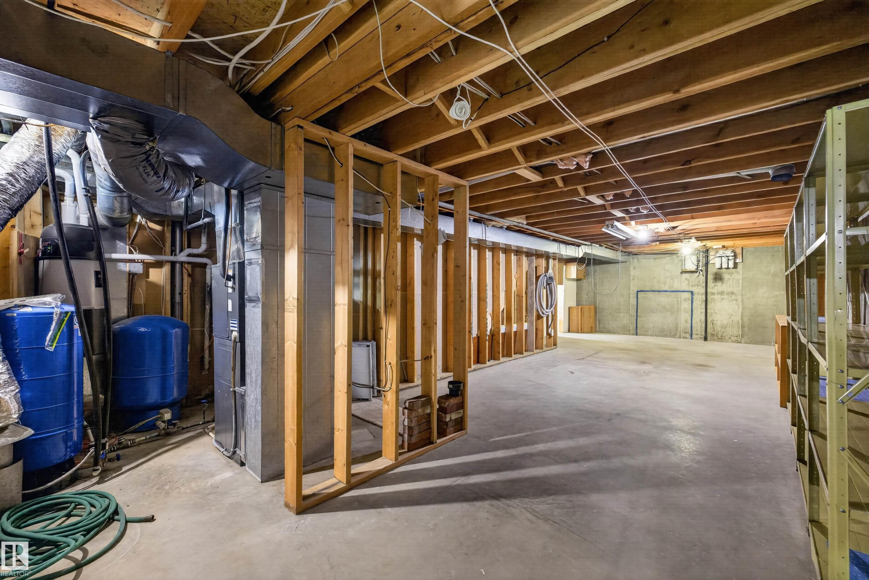Unfinished basement featuring exposed wood joists, concrete flooring, and partial wood framing - 19403 Fort Road, Edmonton, AB - Indoor Photo Showing Basement