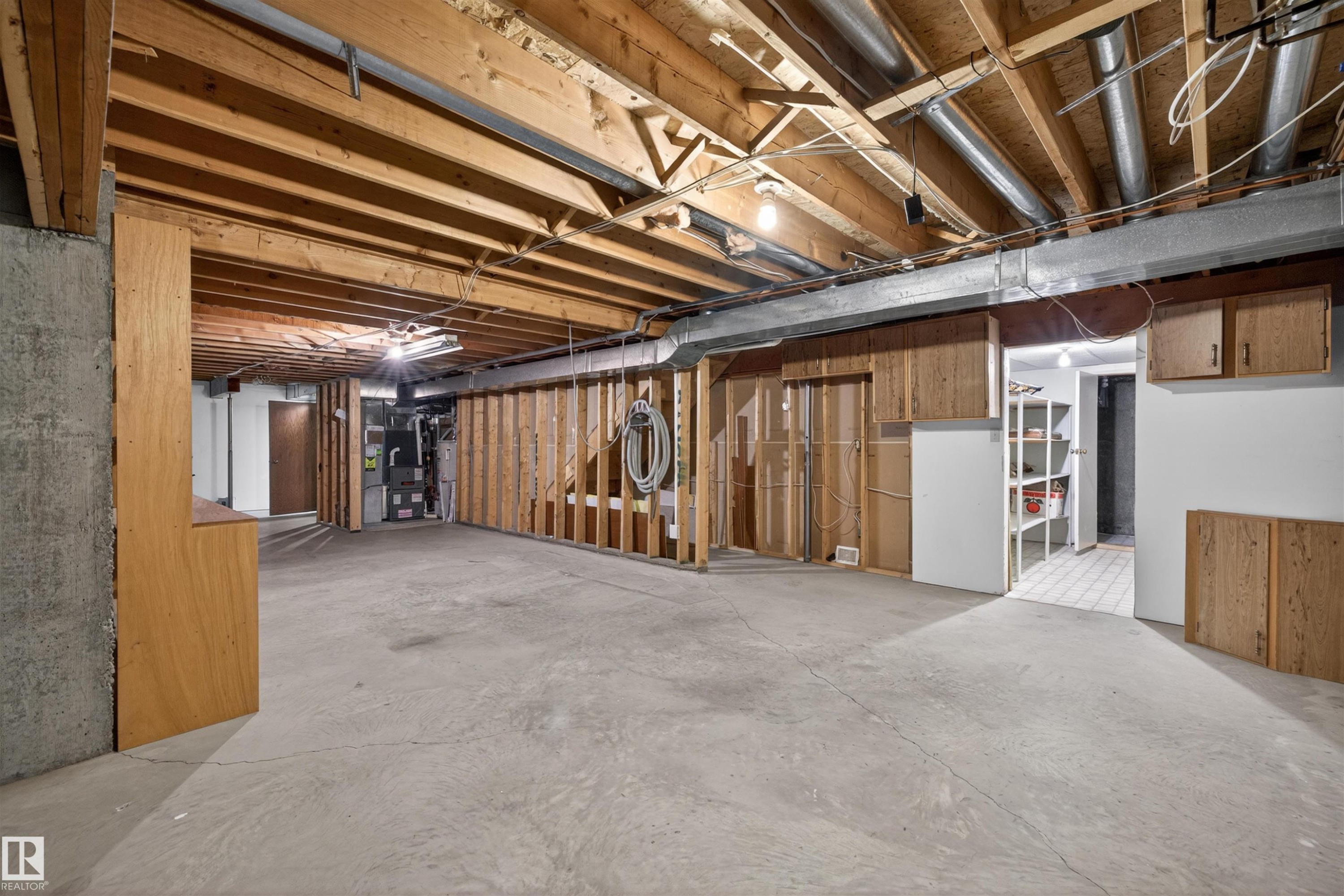 Unfinished basement with exposed ceiling joists, concrete flooring, and partial wood-frame wall construction - 19403 Fort Road, Edmonton, AB - Indoor Photo Showing Basement