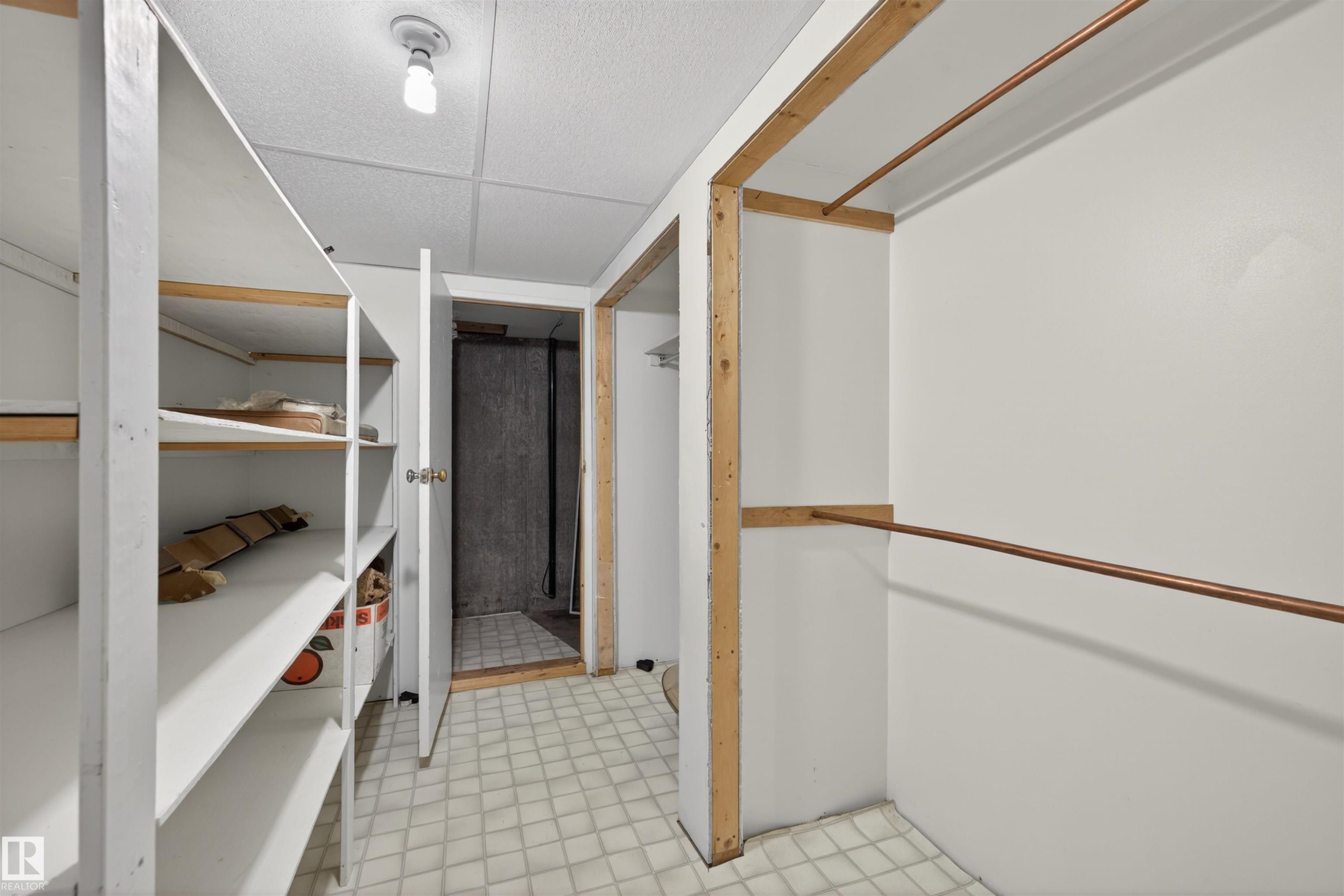 Utility room with built-in shelving, two hanging rods, and an overhead light fixture - 19403 Fort Road, Edmonton, AB - Indoor Photo Showing Other Room