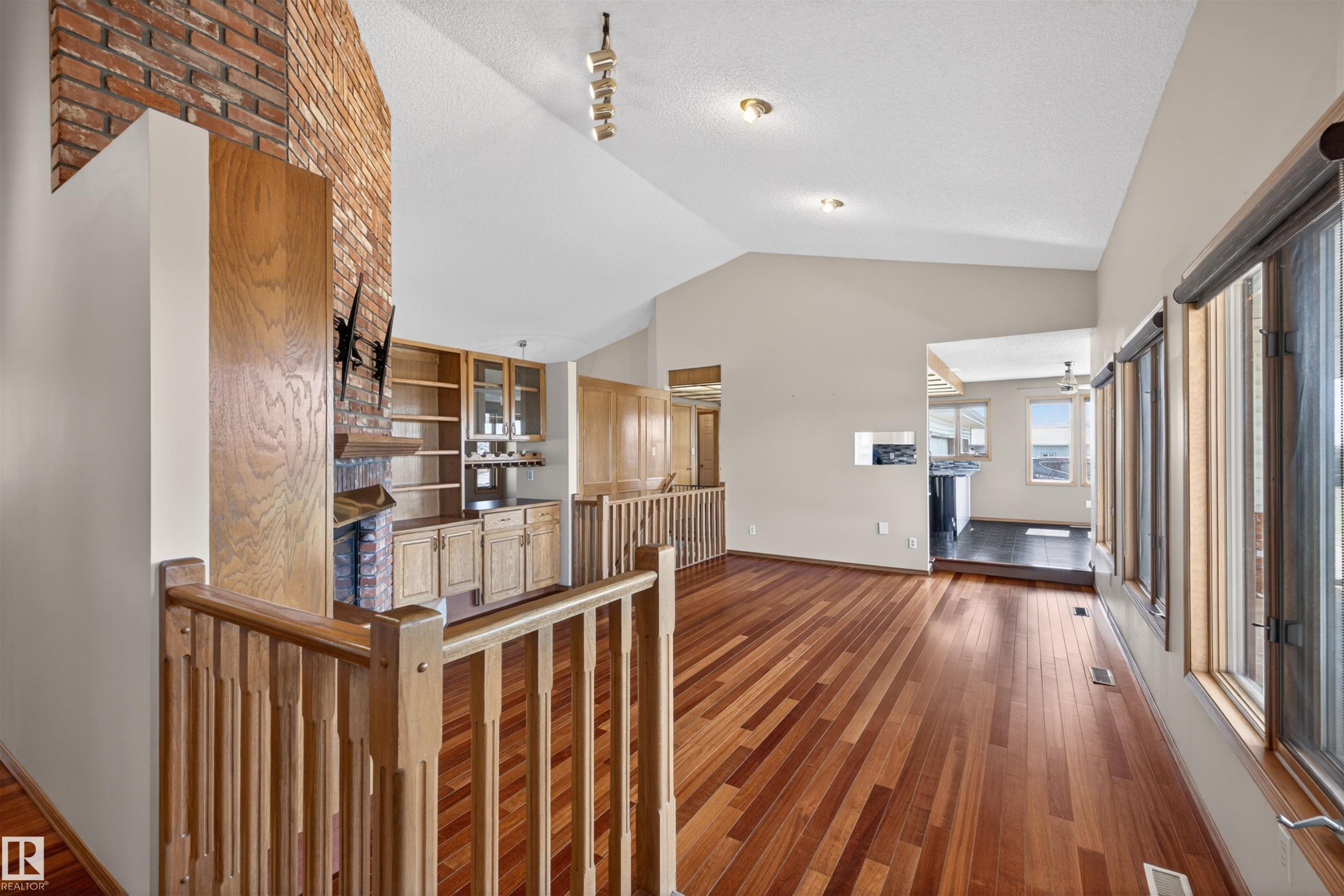 Vaulted ceilings and wood-finish flooring characterize this open living area - 19403 Fort Road, Edmonton, AB - Indoor Photo Showing Other Room