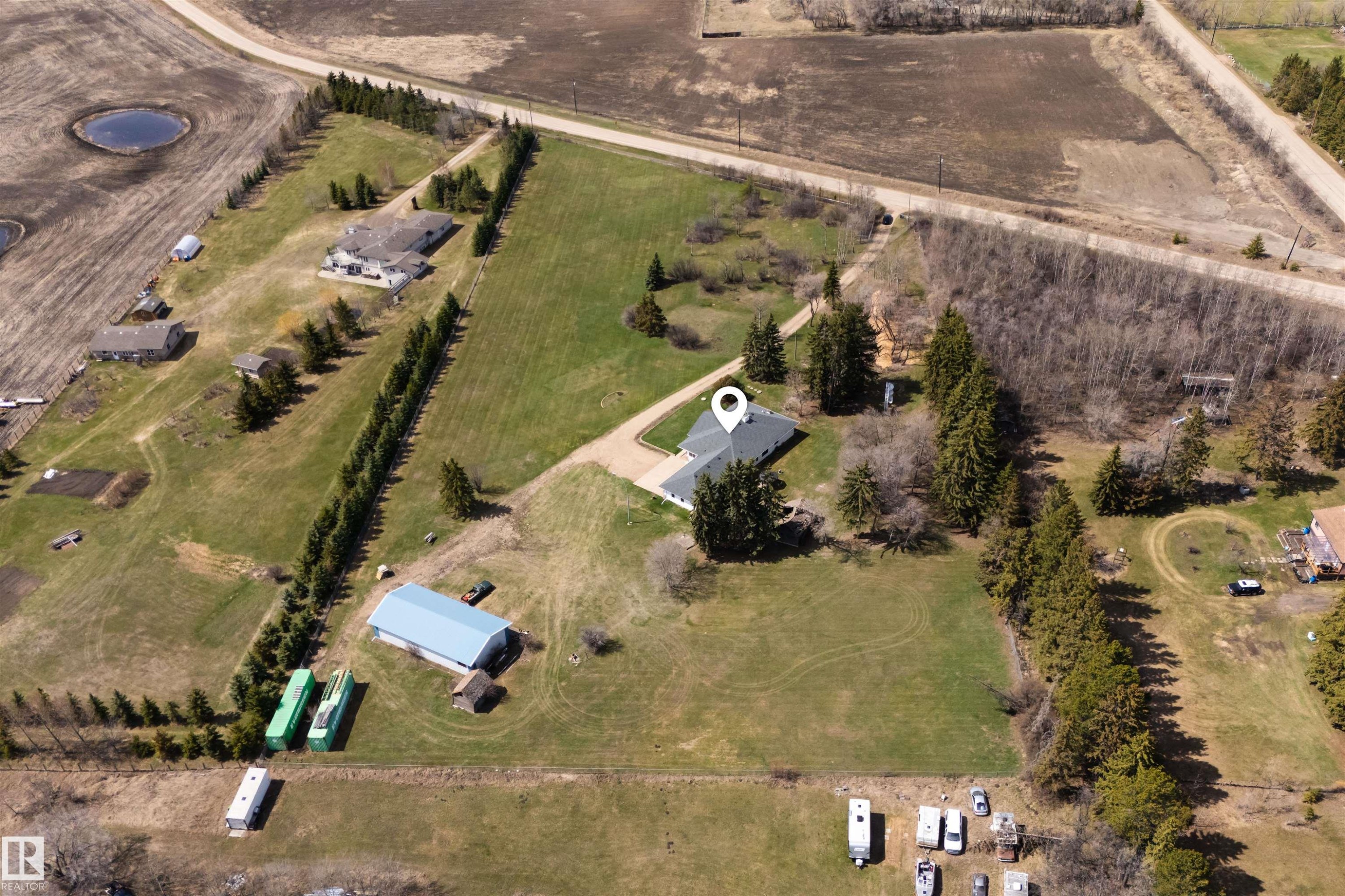 Expansive rural property featuring a single-story residence with a dark roof and surrounding mature trees - 19403 Fort Road, Edmonton, AB - Outdoor With View