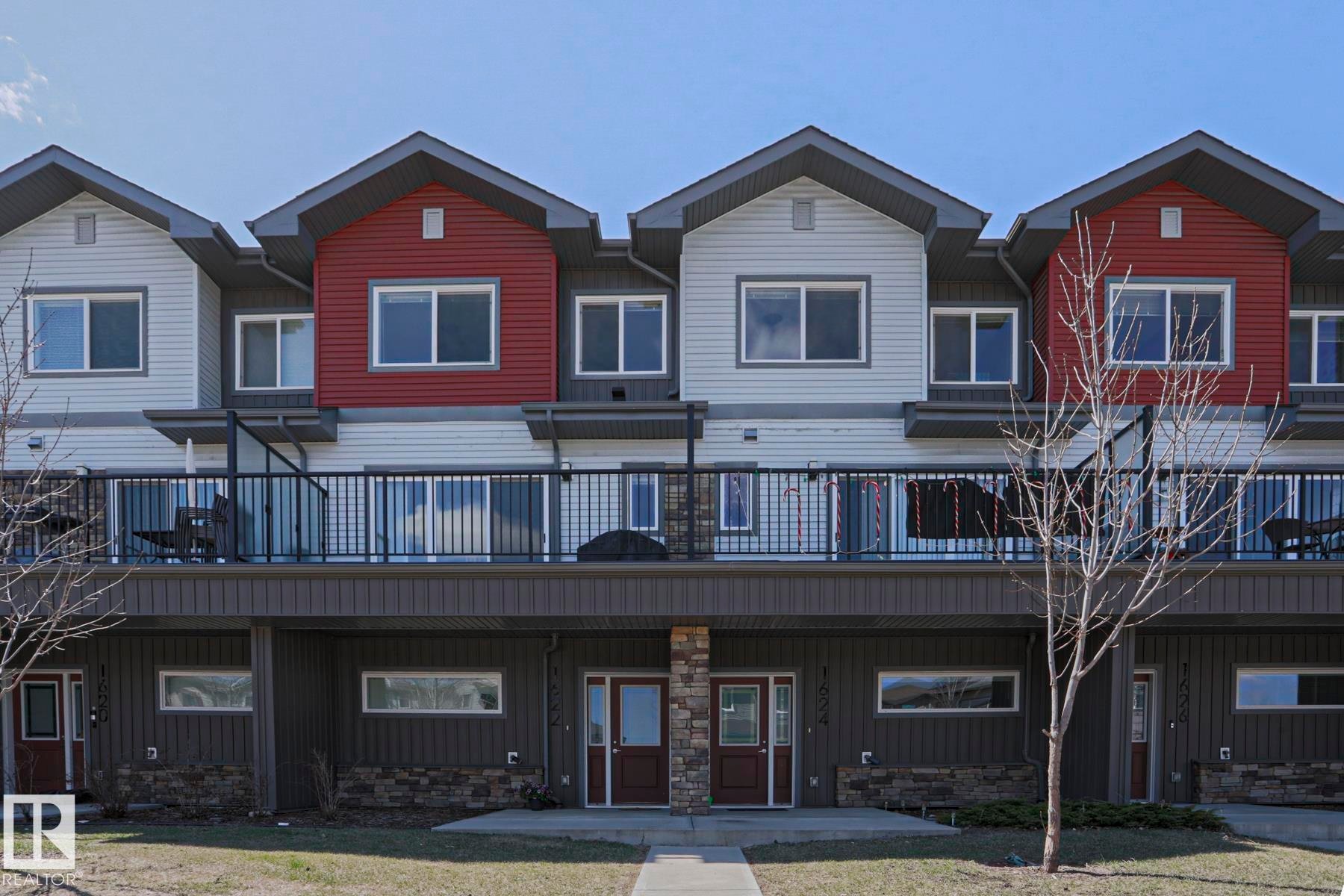 Row of modern townhomes featuring multi-level facades with light grey and red siding accents - 1622 33A Street Nw, Edmonton, AB - Outdoor With Balcony With Deck Patio Veranda With Facade