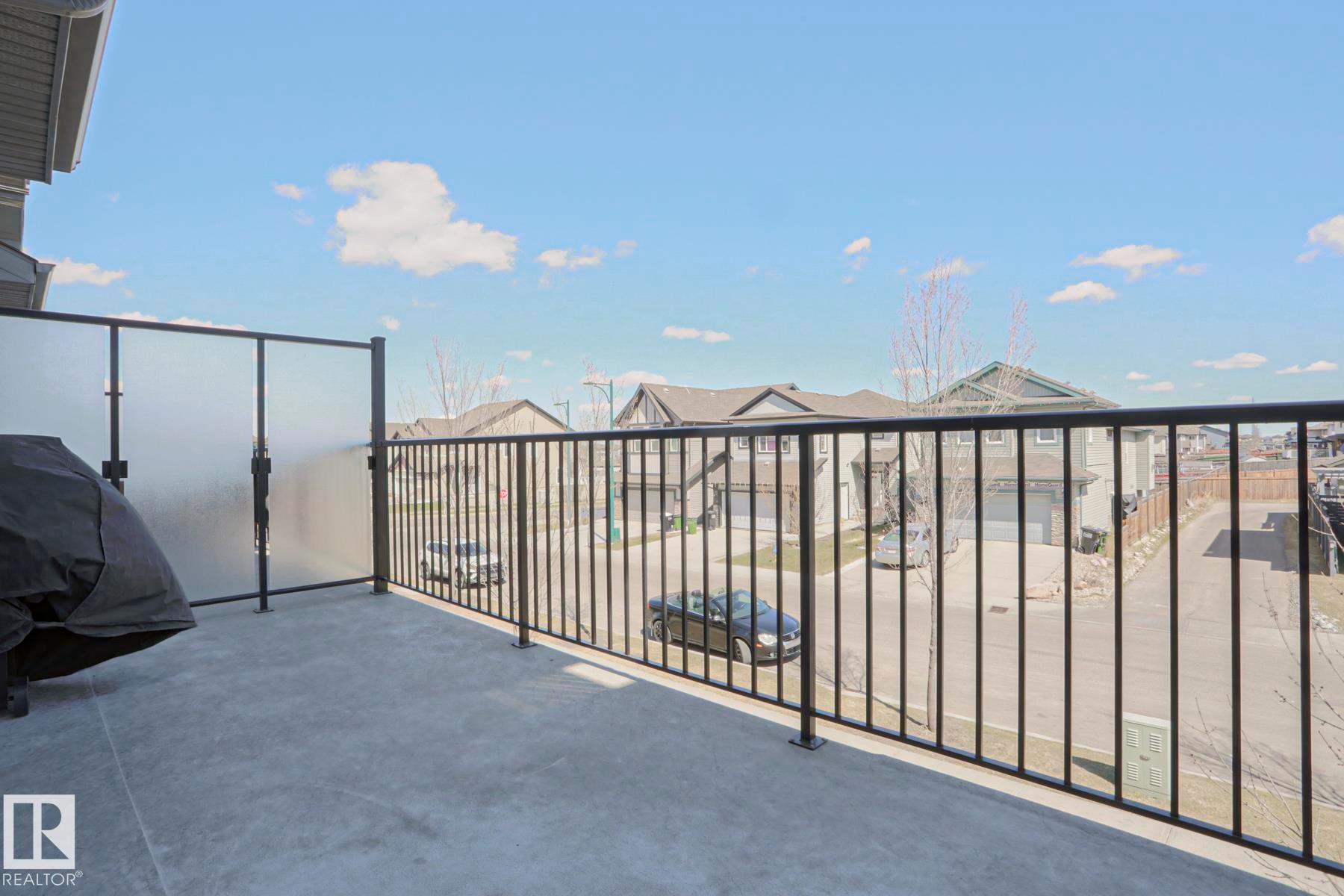 Private balcony featuring a concrete surface, black metal railings, and frosted glass privacy panels - 1622 33A Street Nw, Edmonton, AB - Outdoor With Balcony