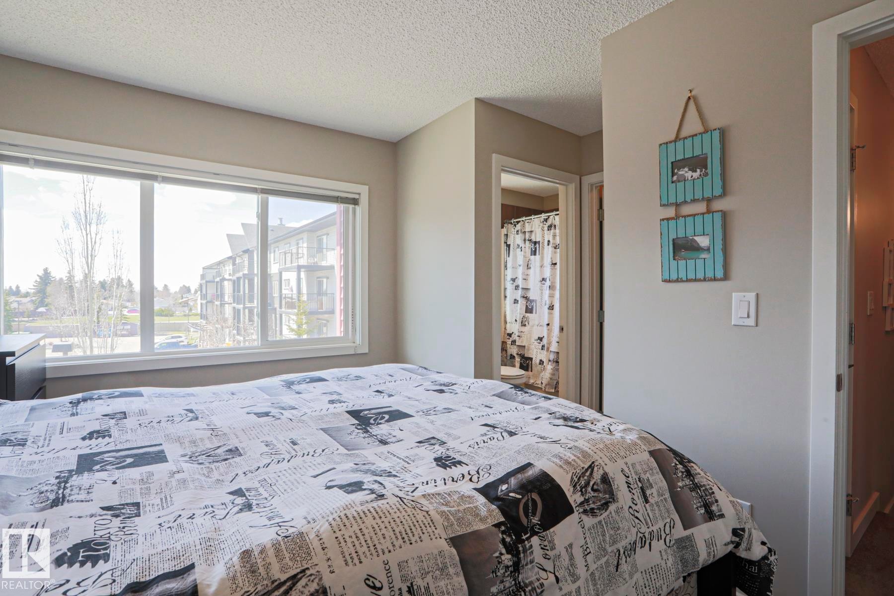Master Bedroom Very Bright room featuring a large window, neutral wall paint, and textured ceiling - 1622 33A Street Nw, Edmonton, AB - Indoor Photo Showing Bedroom