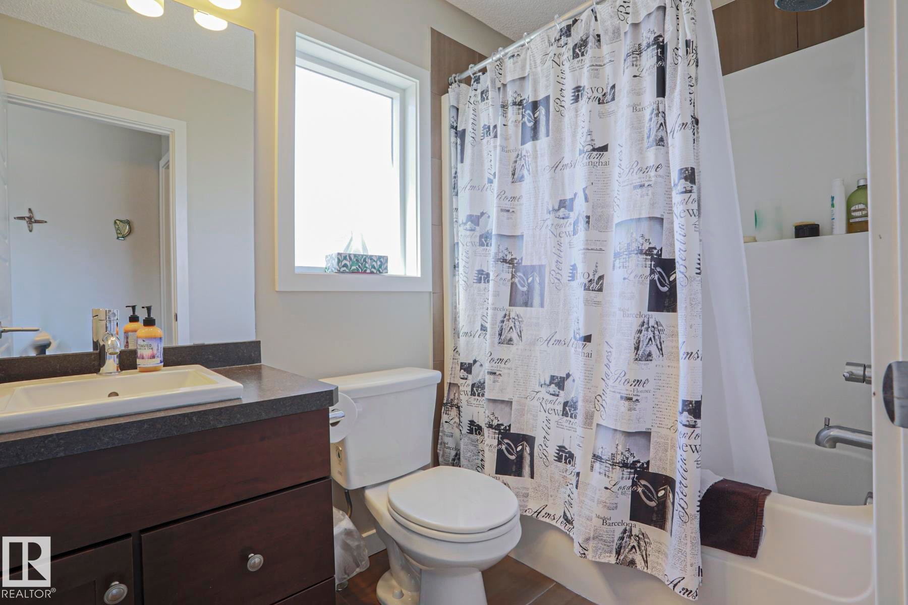 Master Bedroom convenient 4 piece Bathroom featuring a white rectangular sink, dark wood-finish vanity with chrome hardware, an integrated mirror, and a white toilet - 1622 33A Street Nw, Edmonton, AB - Indoor Photo Showing Bathroom