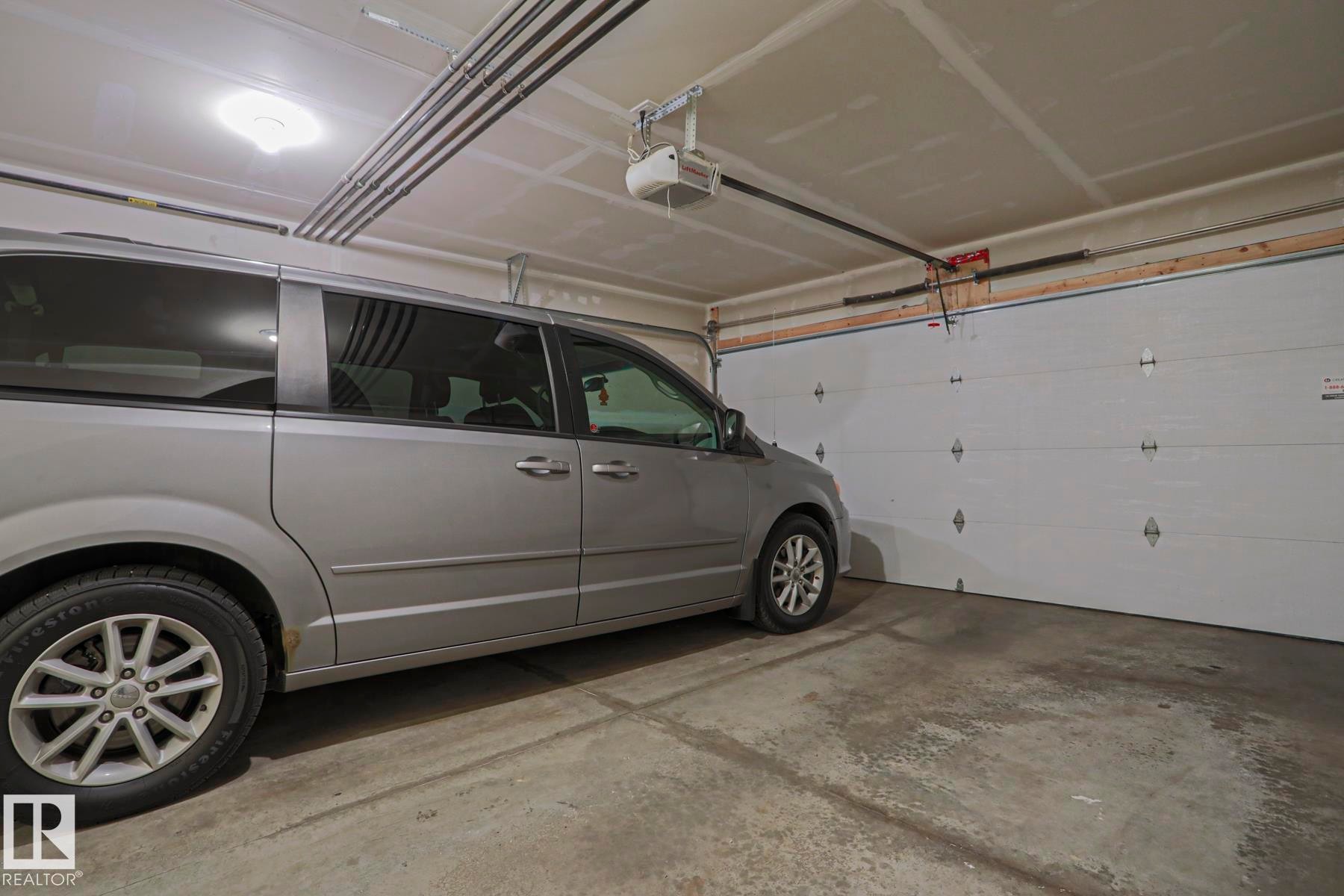 Very Spacious 2 care attached garage with concrete flooring, overhead lighting, and a white panel garage door - 1622 33A Street Nw, Edmonton, AB - Indoor Photo Showing Garage