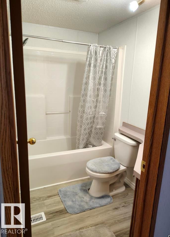 Bathroom with an integrated tub and shower combination featuring a white surround - 109-4819 51 Ave, Millet, AB - Indoor Photo Showing Bathroom