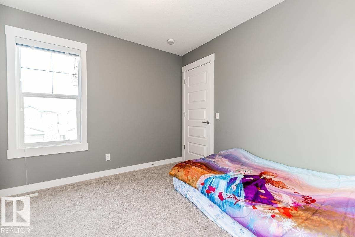 Light gray wall paint complemented by white baseboards and window trim - 9748 205 Street, Edmonton, AB - Indoor Photo Showing Bedroom