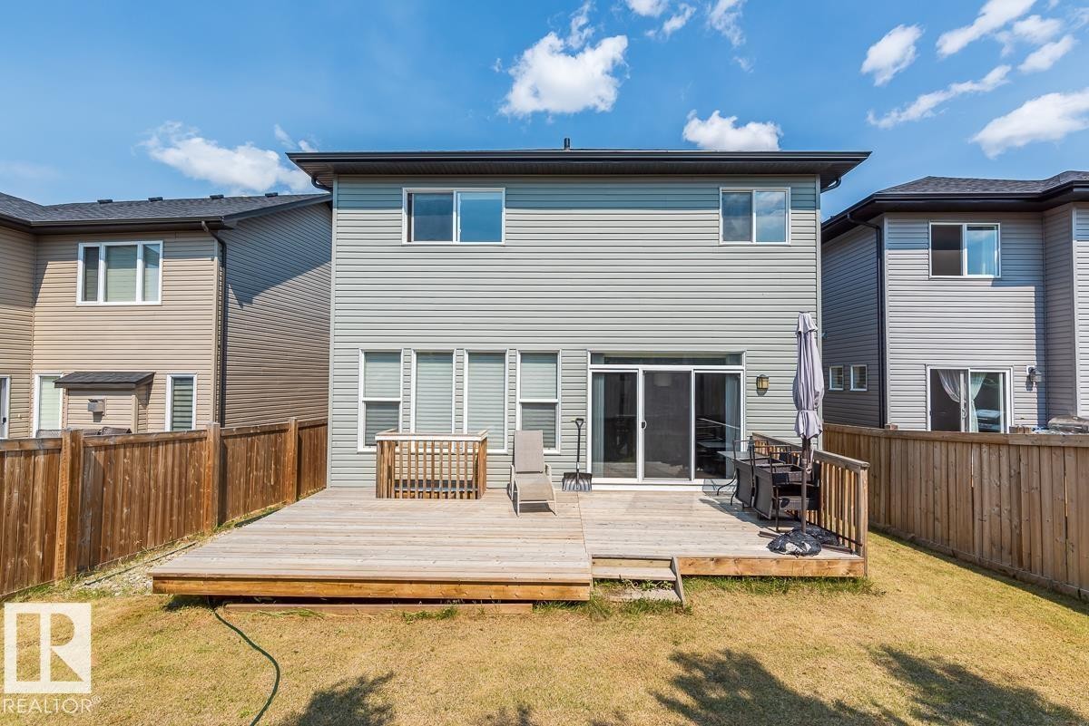 Rear exterior featuring a multi-level wood deck, privacy fencing, and sliding glass door access - 9748 205 Street, Edmonton, AB - Outdoor With Deck Patio Veranda With Exterior