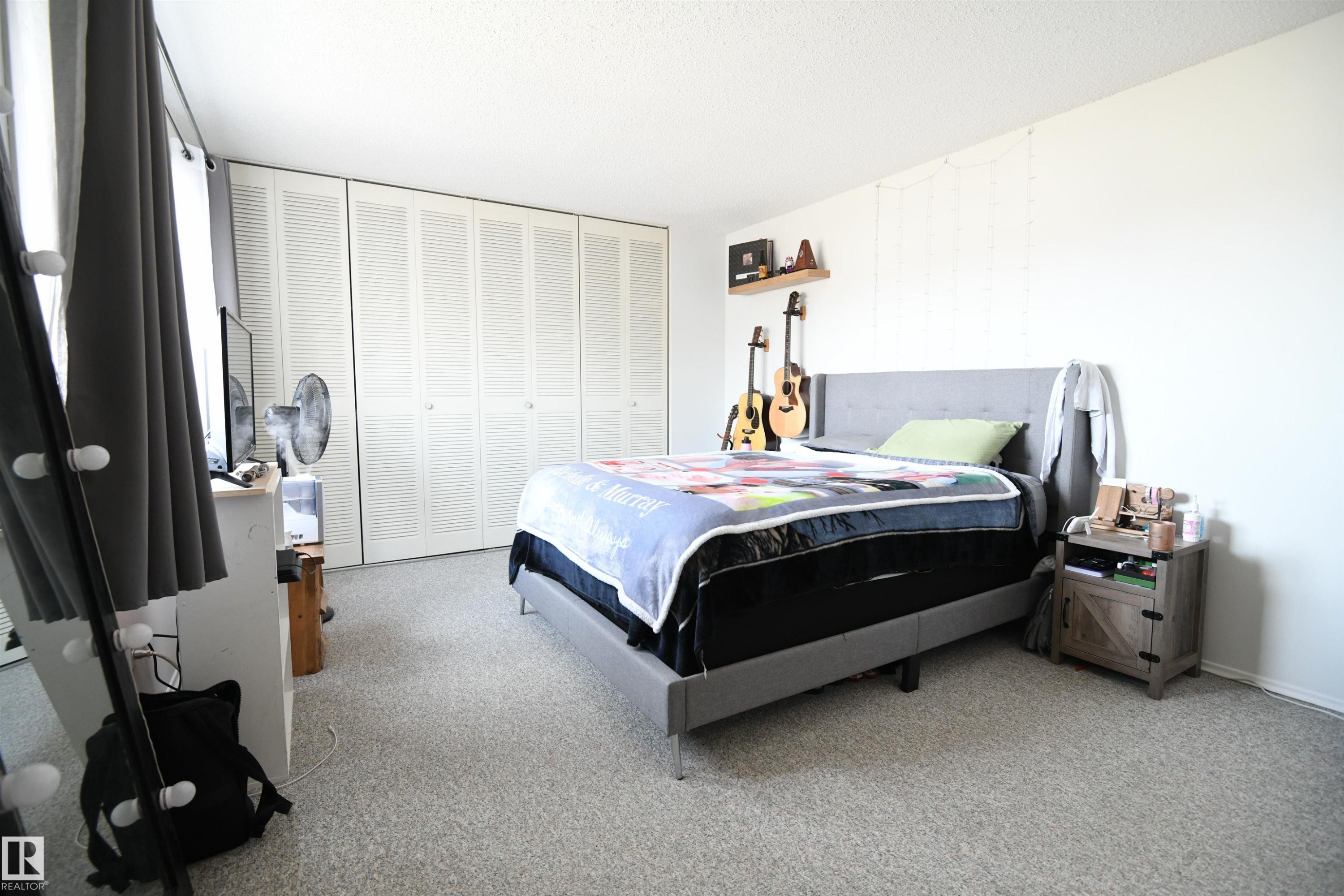 The master bedroom easily supports king sized furniture, thanks to it's generous floor space. The full wall of floor to ceiling closets is a nice touch, and provides ample storage - 5823 Riverbend Road, Edmonton, AB - Indoor Photo Showing Bedroom