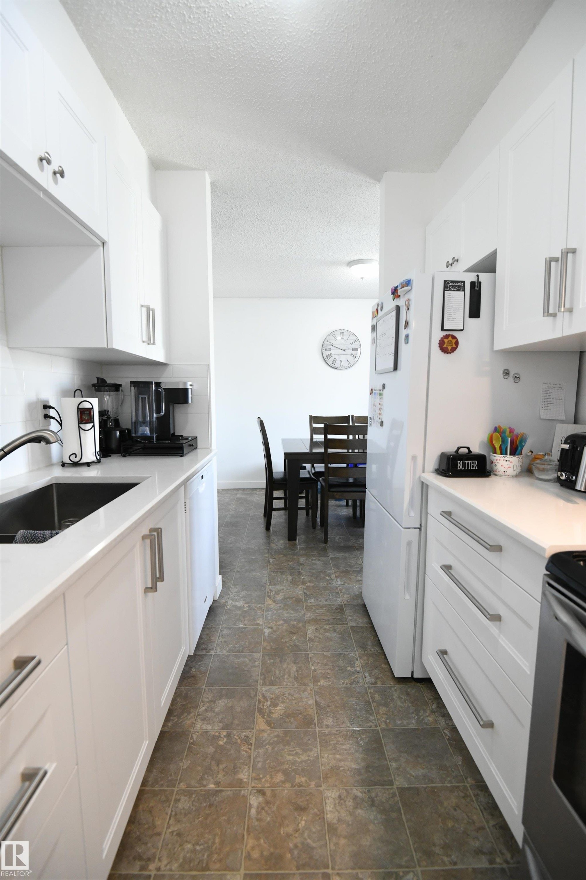 Recent renovations to both bathrooms in the home, as well as the kitchen, are standouts here. White shaker cabinetry, solid surface counters, undermount sink, tile backsplash, a full sized pantry and more - 5823 Riverbend Road, Edmonton, AB - Indoor Photo Showing Kitchen