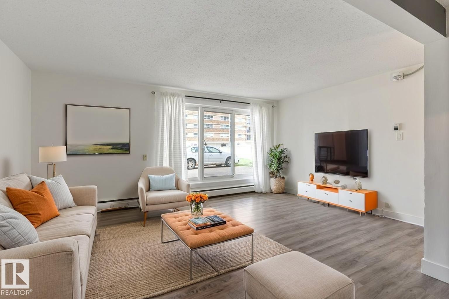 Spacious living area featuring west facing patio doors. - 101 8604 Gateway Boulevard, Edmonton, AB - Indoor Photo Showing Living Room