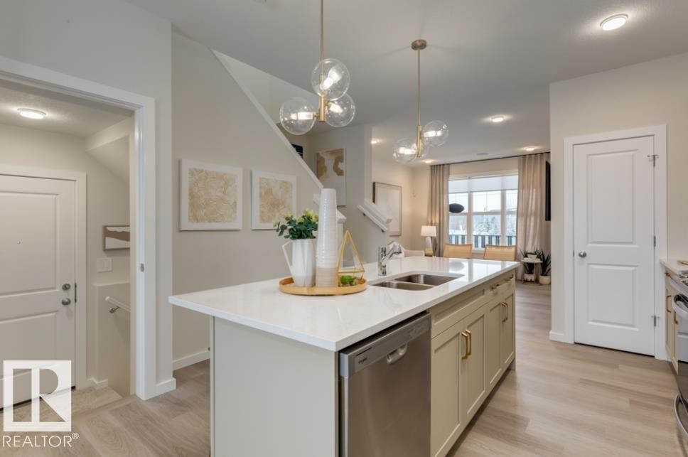 Kitchen island featuring a double-basin sink and stainless steel dishwasher - 720 Southfork Drive, Leduc, AB - Indoor Photo Showing Kitchen With Double Sink