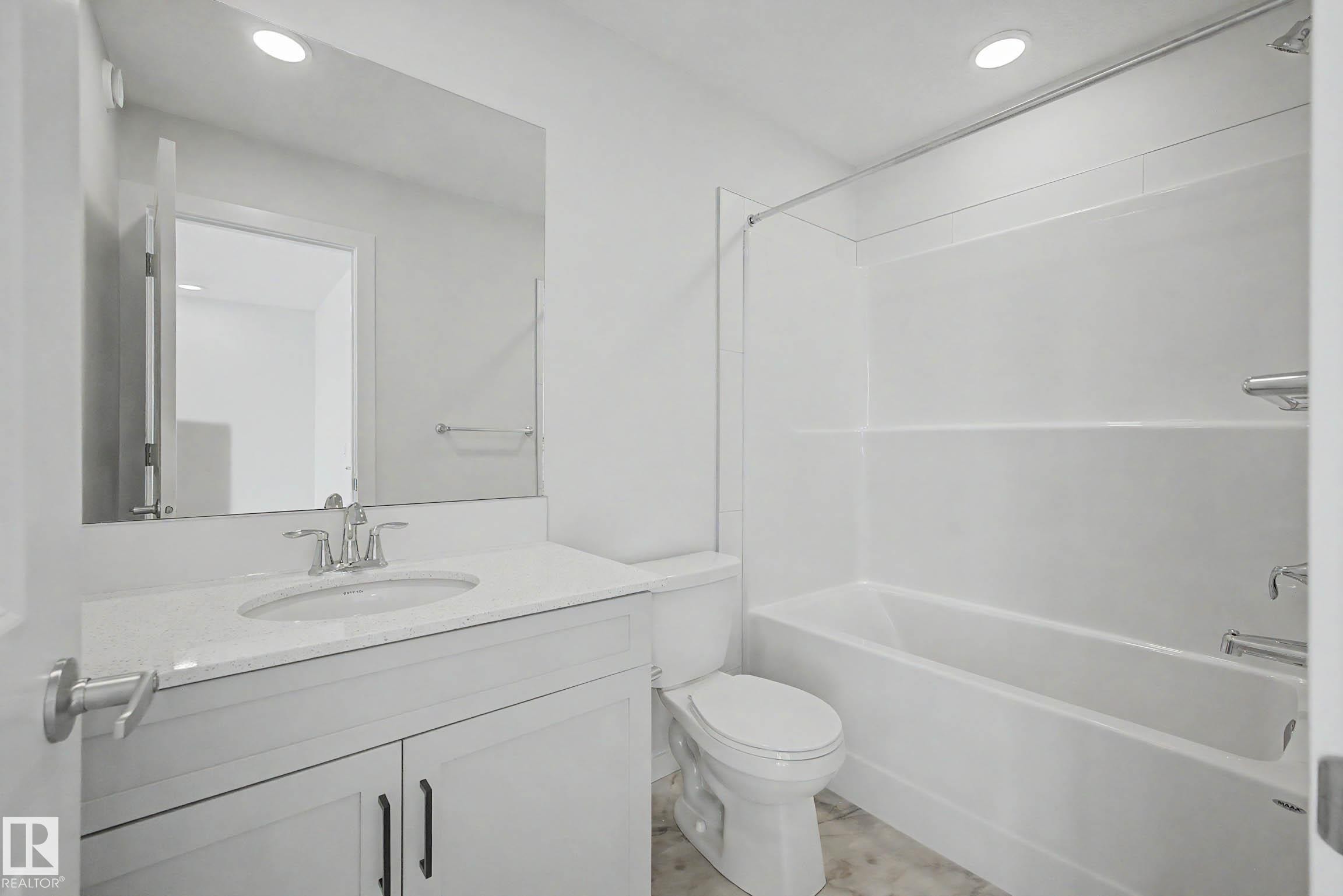 Bathroom featuring a white vanity with a light-toned countertop, a rectangular undermount sink, and a chrome faucet - 720 Southfork Drive, Leduc, AB - Indoor Photo Showing Bathroom