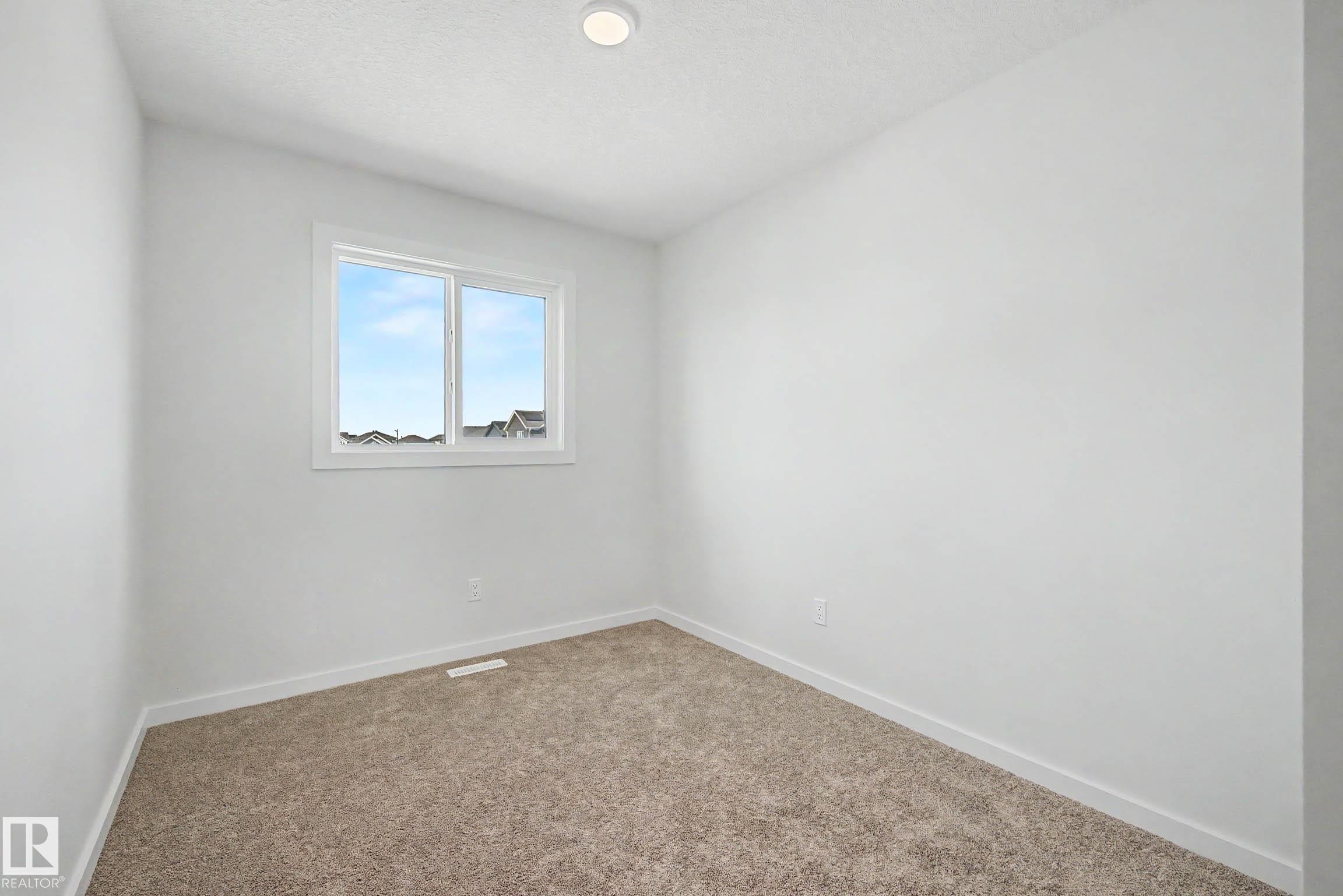 Bright room featuring a large window, neutral paint, recessed lighting, and soft carpeting - 720 Southfork Drive, Leduc, AB - Indoor Photo Showing Other Room
