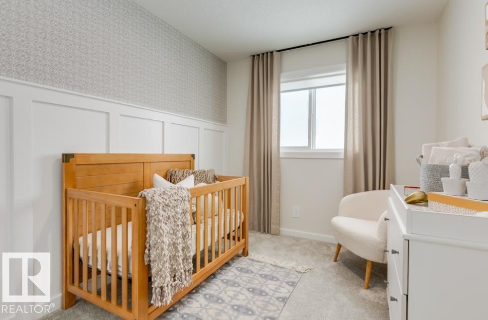 Room featuring board and batten wall paneling, patterned wallpaper, and light gray carpeting - 720 Southfork Drive, Leduc, AB - Indoor Photo Showing Bedroom