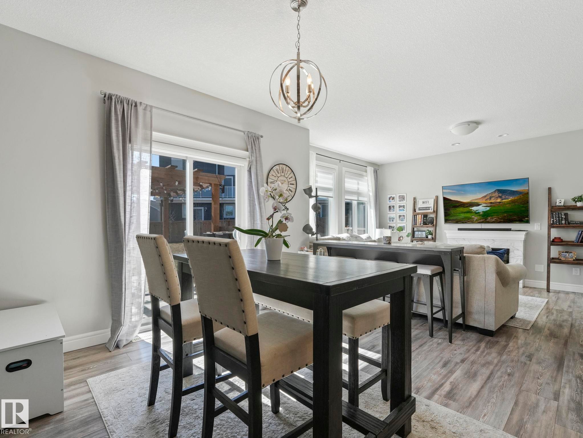 Open-concept living area featuring wood-finish flooring, recessed lighting, and a contemporary spherical chandelier - 3817 Robins Crescent, Edmonton, AB - Indoor Photo Showing Dining Room