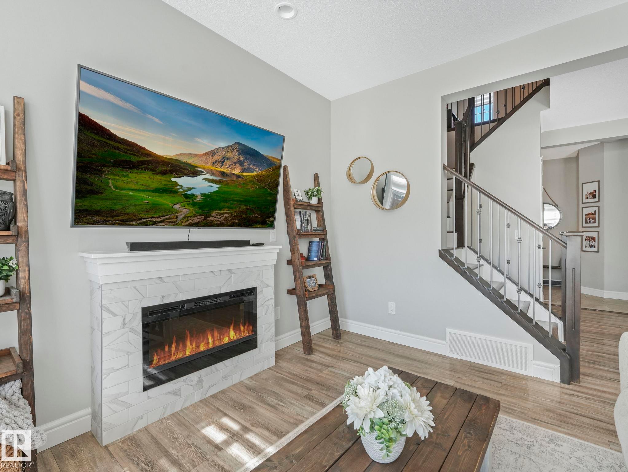 Fireplace with marble-look tile surround and white mantel - 3817 Robins Crescent, Edmonton, AB - Indoor Photo Showing Living Room With Fireplace