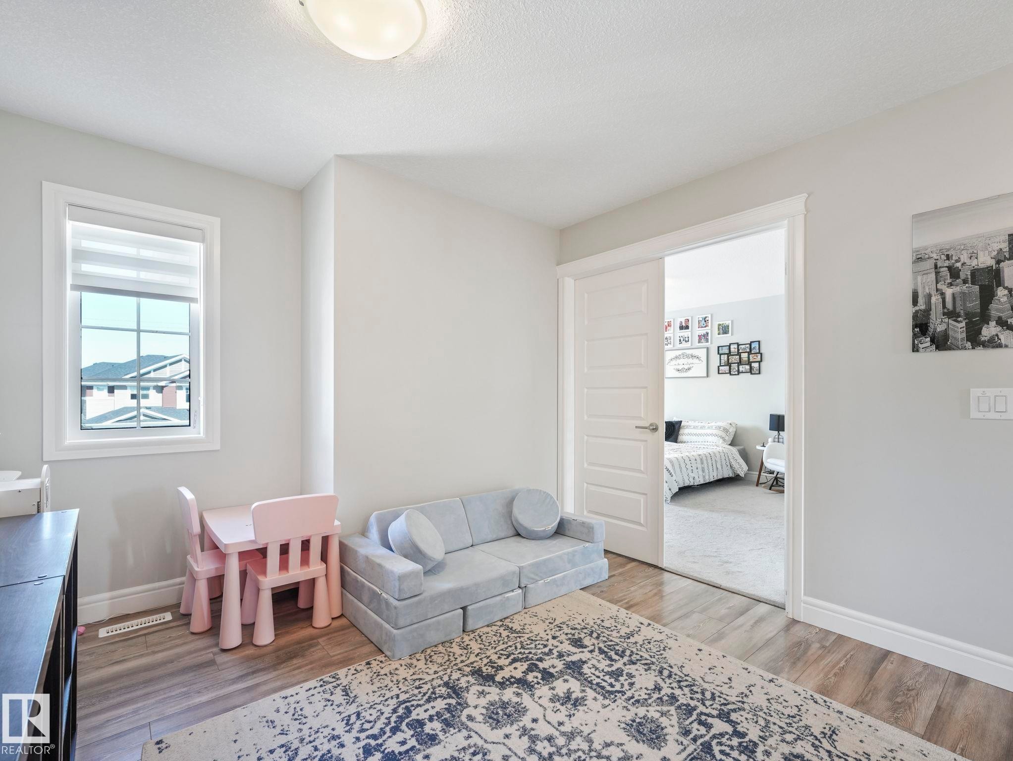 Bright interior space featuring wood-finish flooring and a white trim package - 3817 Robins Crescent, Edmonton, AB - Indoor Photo Showing Other Room