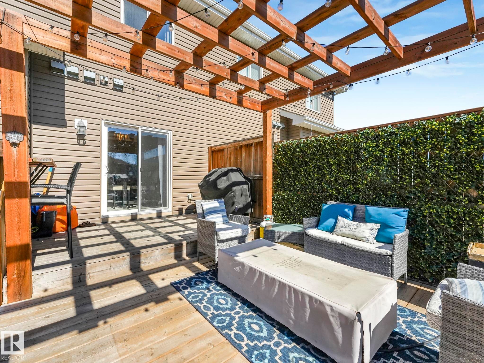 Expansive wood deck with a built-in pergola featuring overhead string lights - 3817 Robins Crescent, Edmonton, AB - Outdoor With Exterior