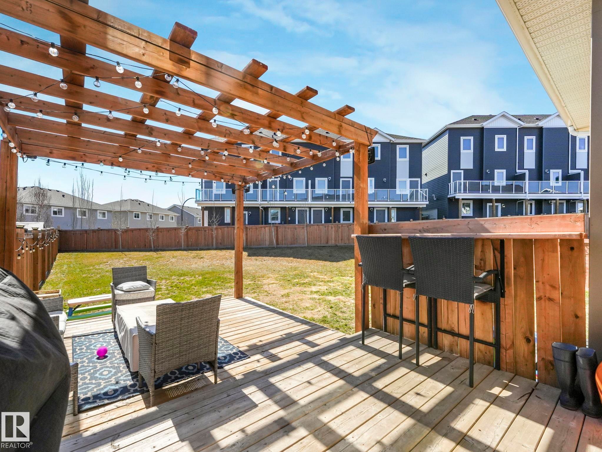 Spacious wooden deck featuring a pergola with string lighting - 3817 Robins Crescent, Edmonton, AB - Outdoor With Deck Patio Veranda