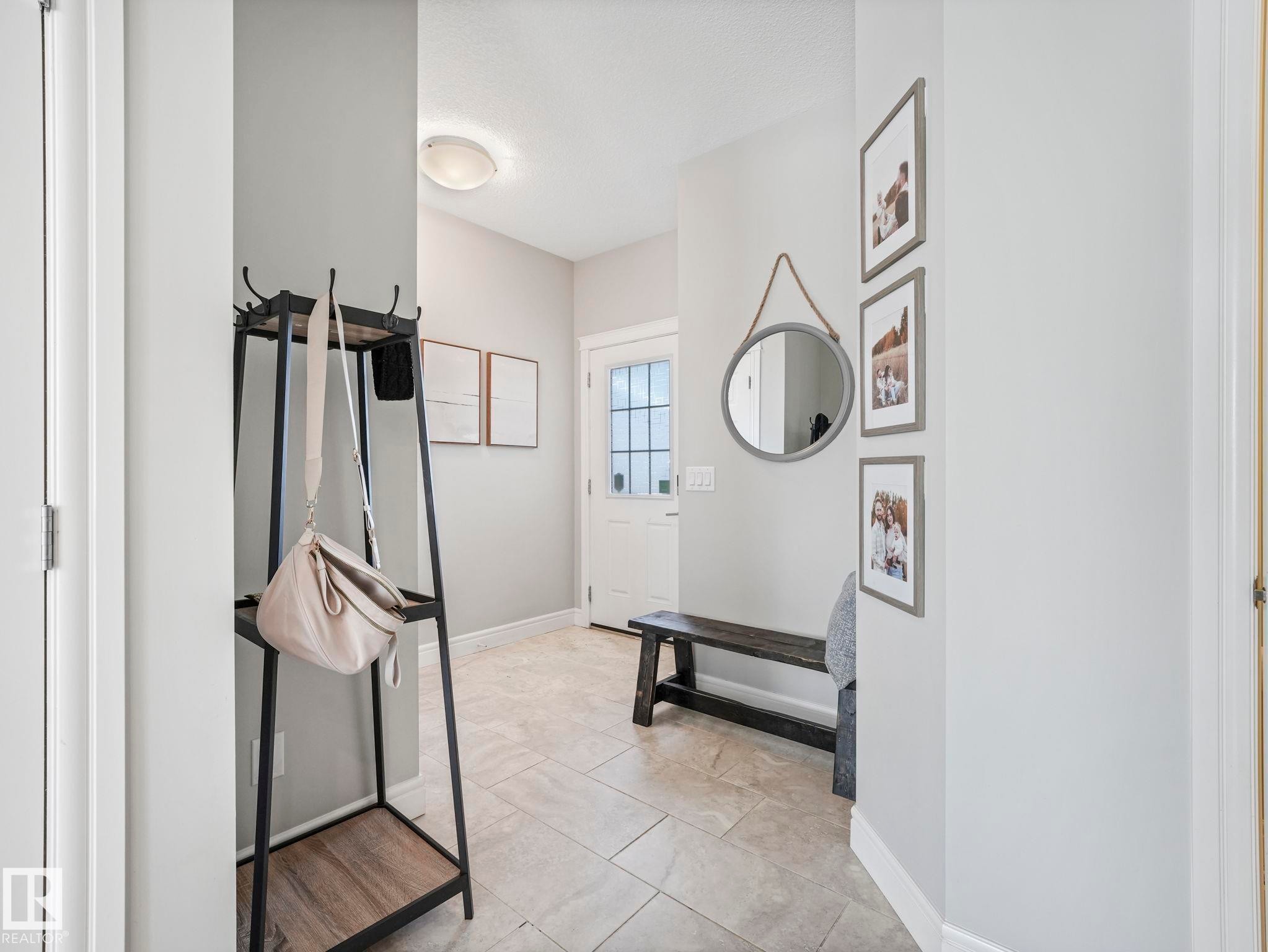 Entryway featuring light-toned tile flooring, light gray wall paint, and a front door with glass windowpanes - 3817 Robins Crescent, Edmonton, AB - Indoor Photo Showing Other Room