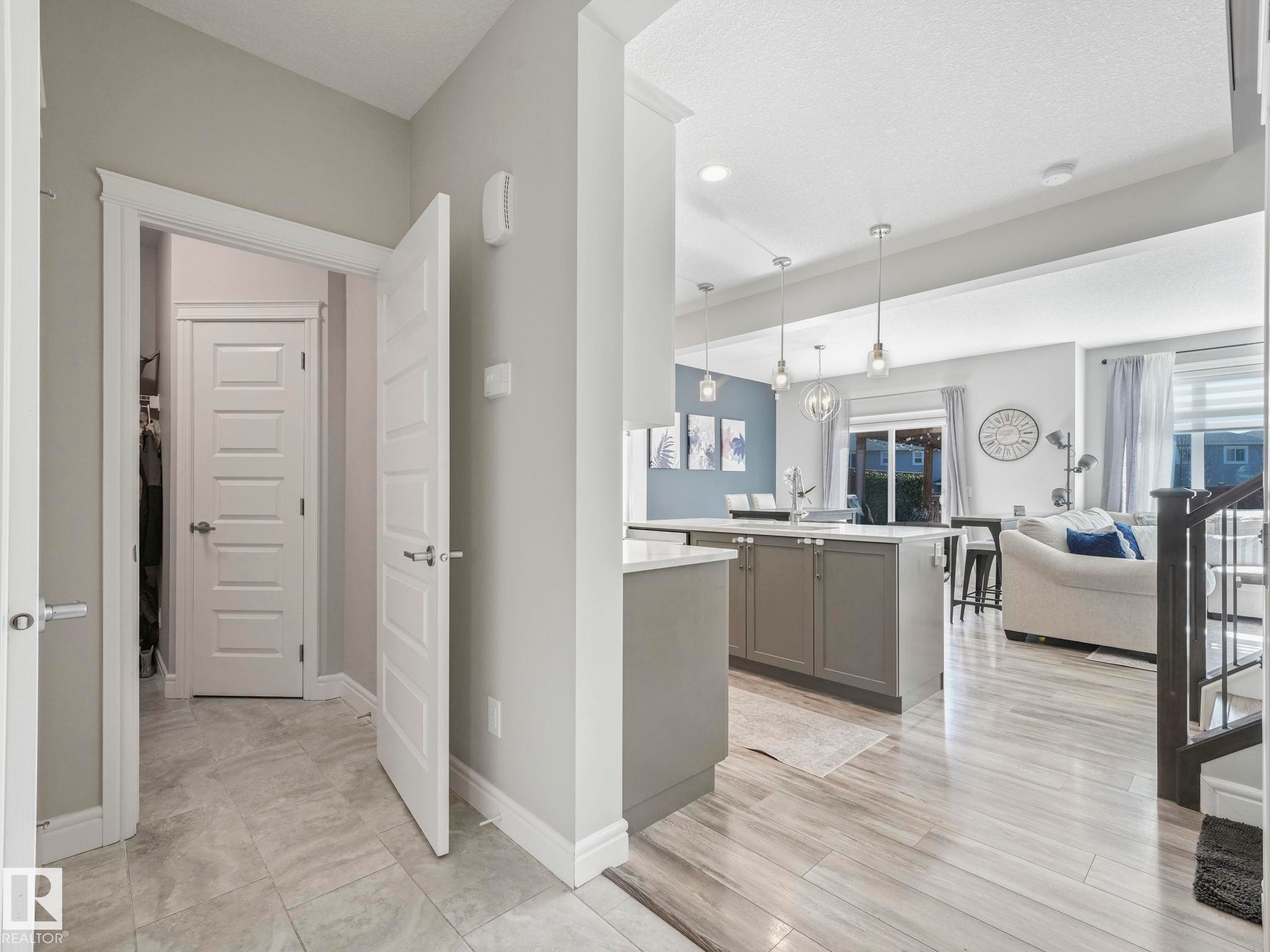 Light wood-finish flooring extending into an open-concept living area - 3817 Robins Crescent, Edmonton, AB - Indoor