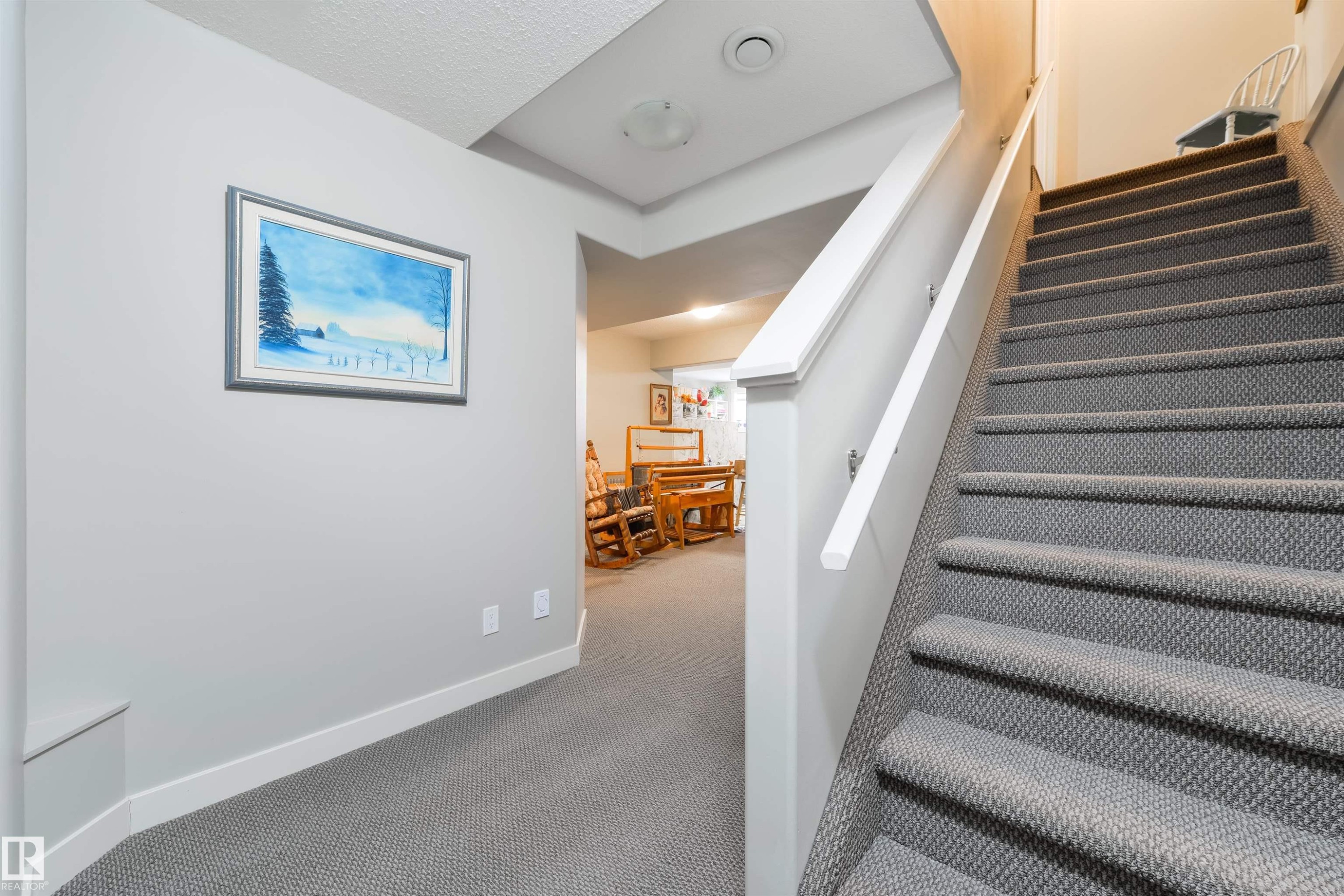 Carpeted staircase featuring a painted wood handrail and trim, with recessed lighting in the ceiling - 4914 47 Street, Redwater, AB - Indoor Photo Showing Other Room