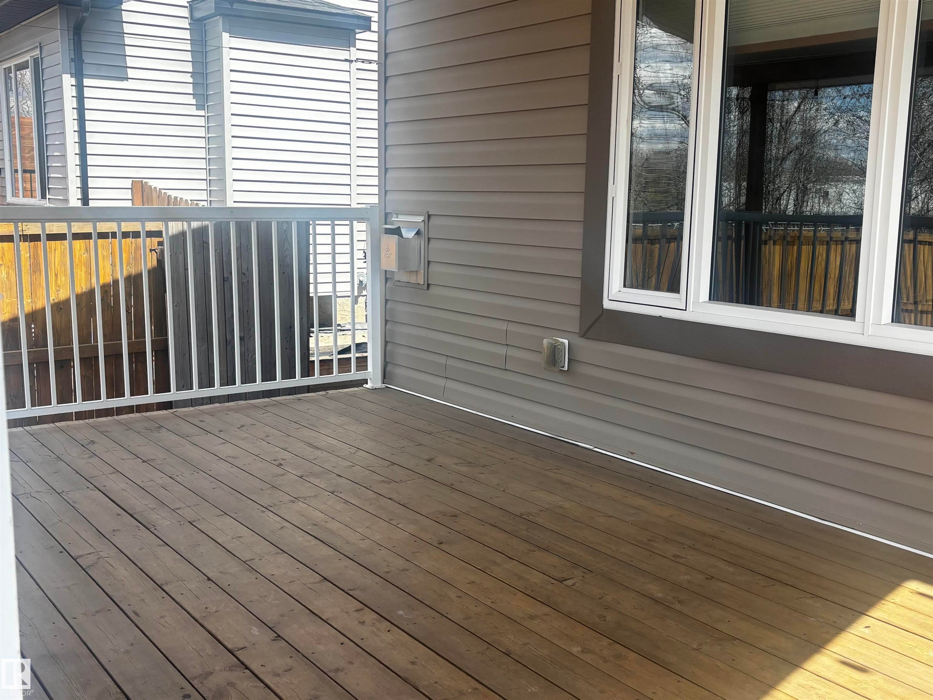 Spacious wood-finish deck with white railings - 4914 47 Street, Redwater, AB - Outdoor With Deck Patio Veranda With Exterior