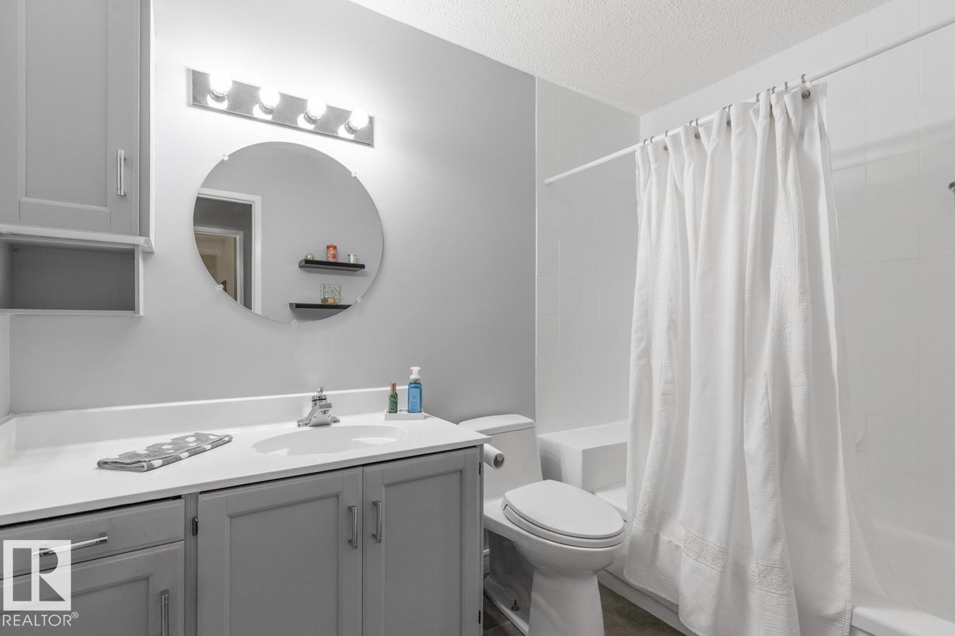 Bathroom featuring a single vanity with gray cabinetry, white countertop, and integrated sink - 10502 158 Street, Edmonton, AB - Indoor Photo Showing Bathroom