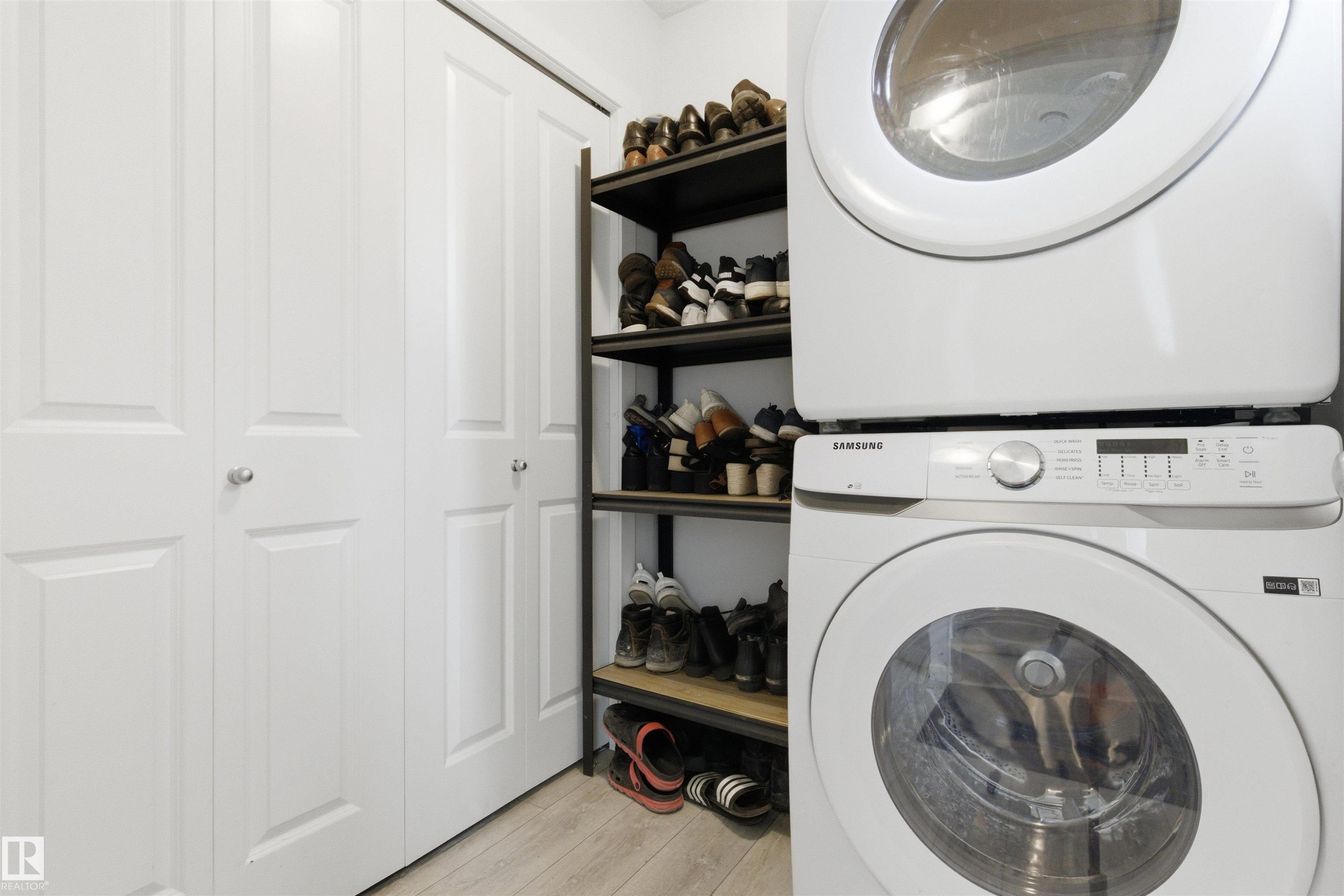 Stackable washer and dryer unit with a visible control panel - 9 850 Secord Boulevard, Edmonton, AB - Indoor Photo Showing Laundry Room