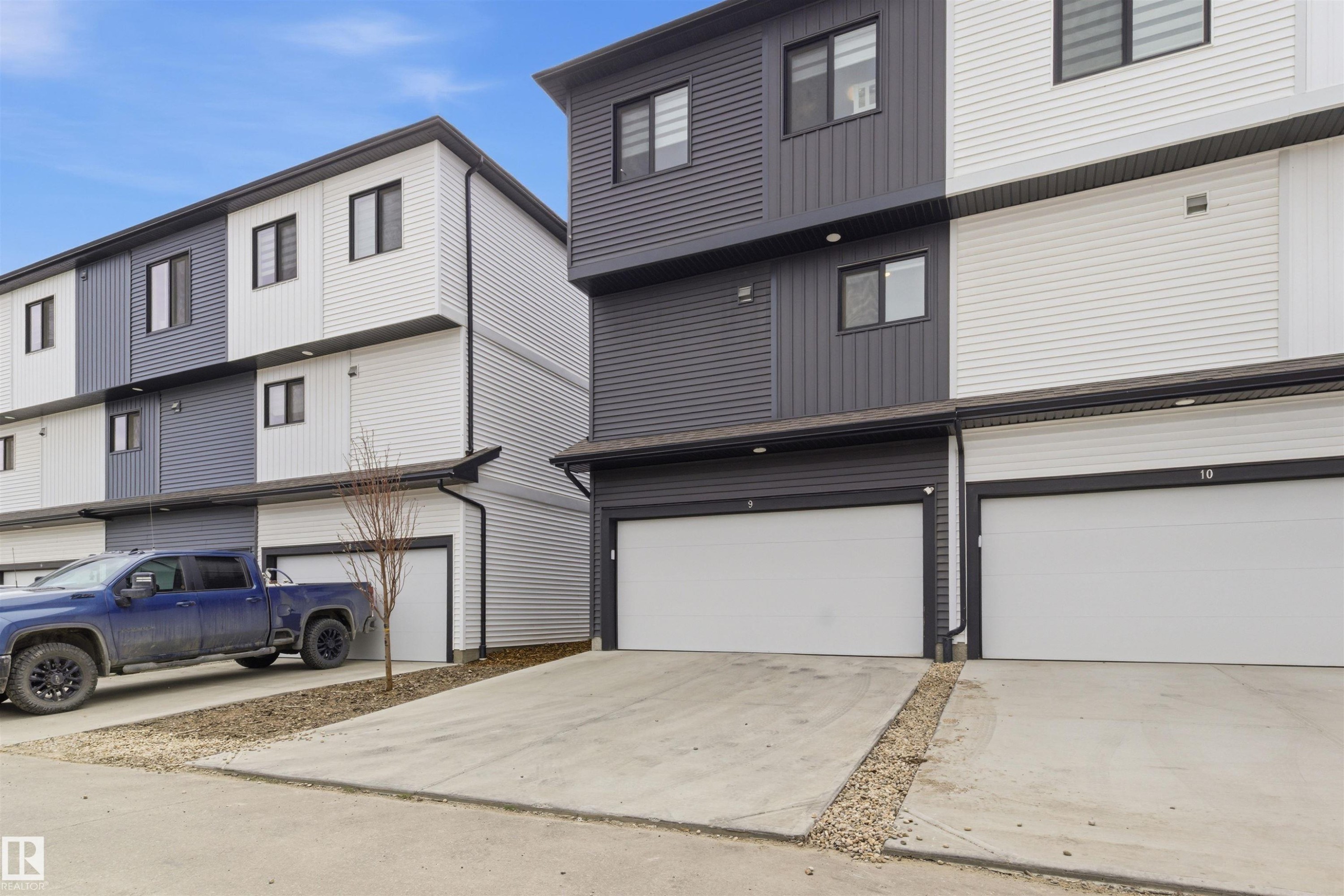 Contemporary multi-level exterior featuring dark and light horizontal siding - 9 850 Secord Boulevard, Edmonton, AB - Outdoor With Exterior