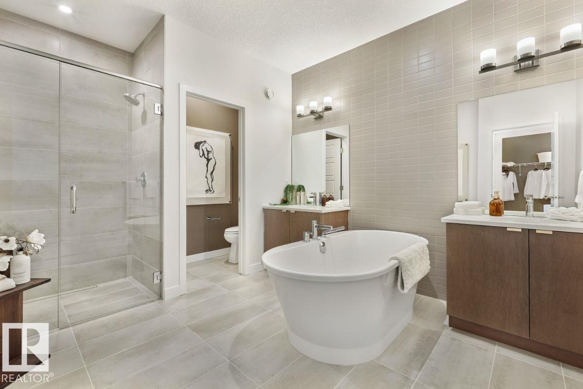 Full bathroom featuring tile walls, a soaking tub, light tile patterned floors, a shower stall, and vanity - 2131 194 Street Nw, Edmonton, AB - Indoor Photo Showing Bathroom
