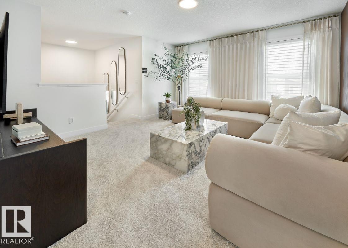 Living area with light colored carpet, a textured ceiling, plenty of natural light, and recessed lighting - 2131 194 Street Nw, Edmonton, AB - Indoor Photo Showing Living Room