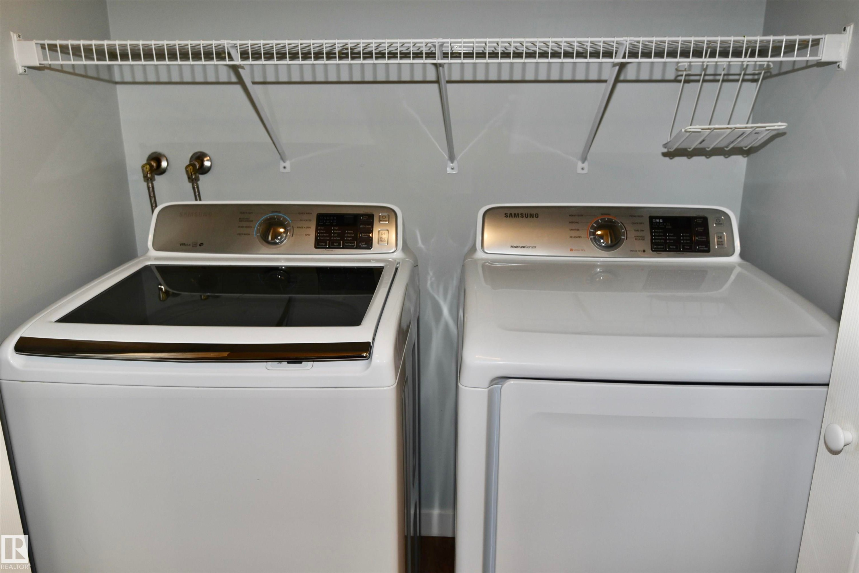 Dedicated insuite laundry area featuring white appliances, a top-load washer, and a front-load dryer - 21 10160 119 Street Nw, Edmonton, AB